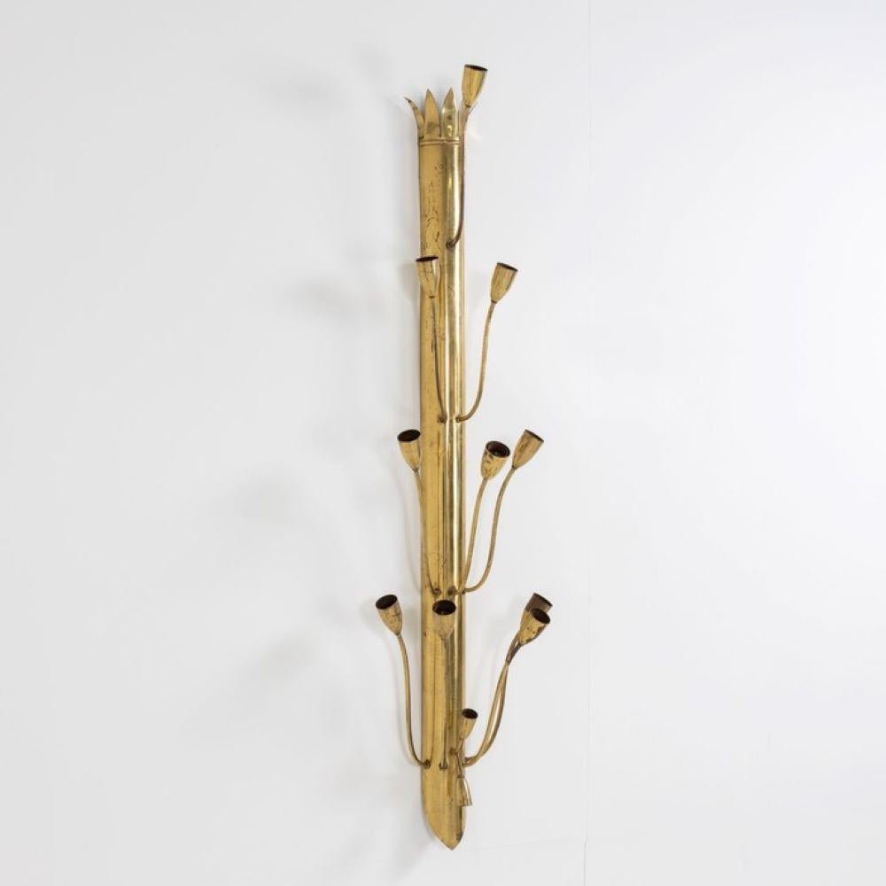 Une seule grande applique murale décorative avec douze bras courbés. Fabriqué en laiton patiné.