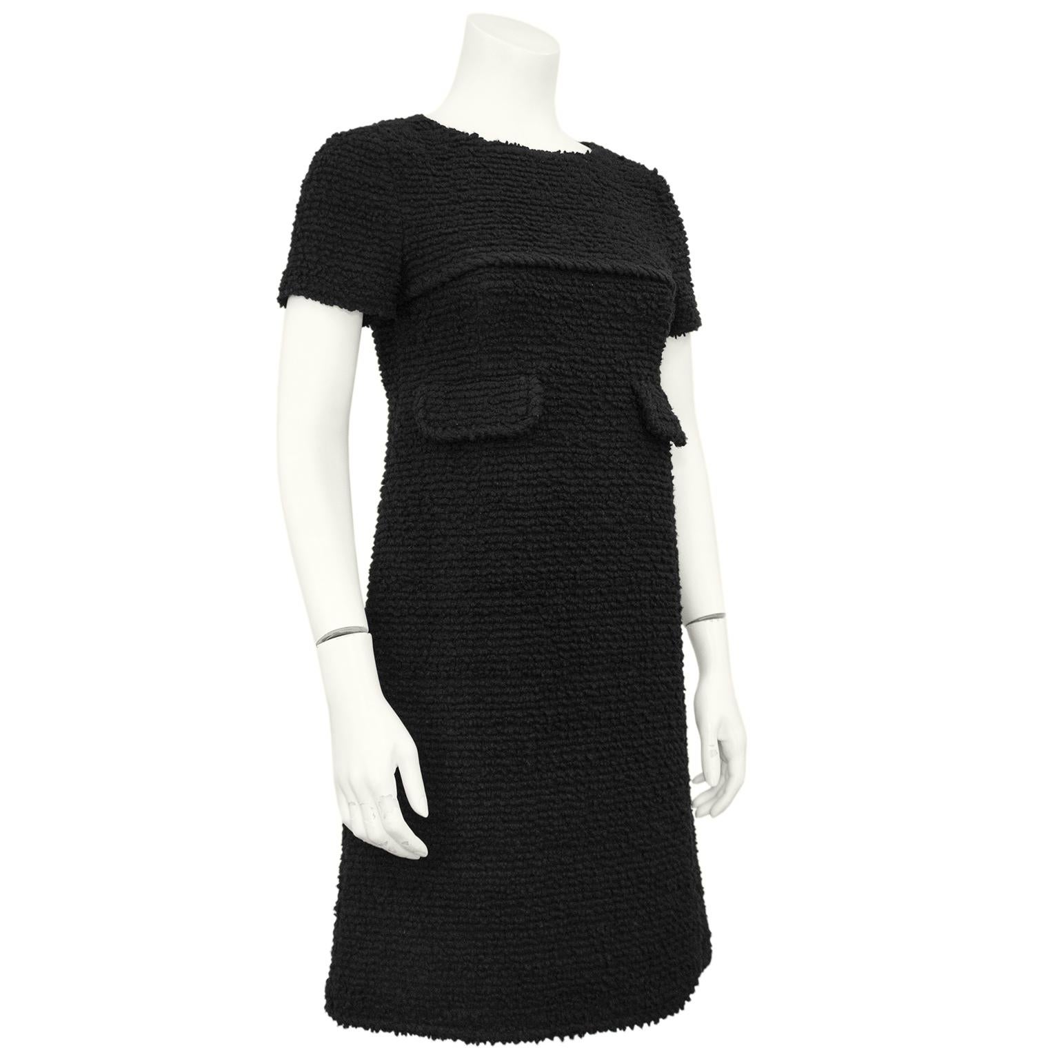 Ein kleines schwarzes Kleid von Chanel ist immer eine gute Wahl! Dieses Chanel Etuikleid stammt aus der Mitte der 2000er Jahre und ist aus einem dicken schwarzen Bouclé gefertigt. Kurze Ärmel mit dickem, gedrehtem Detail am Dotter und