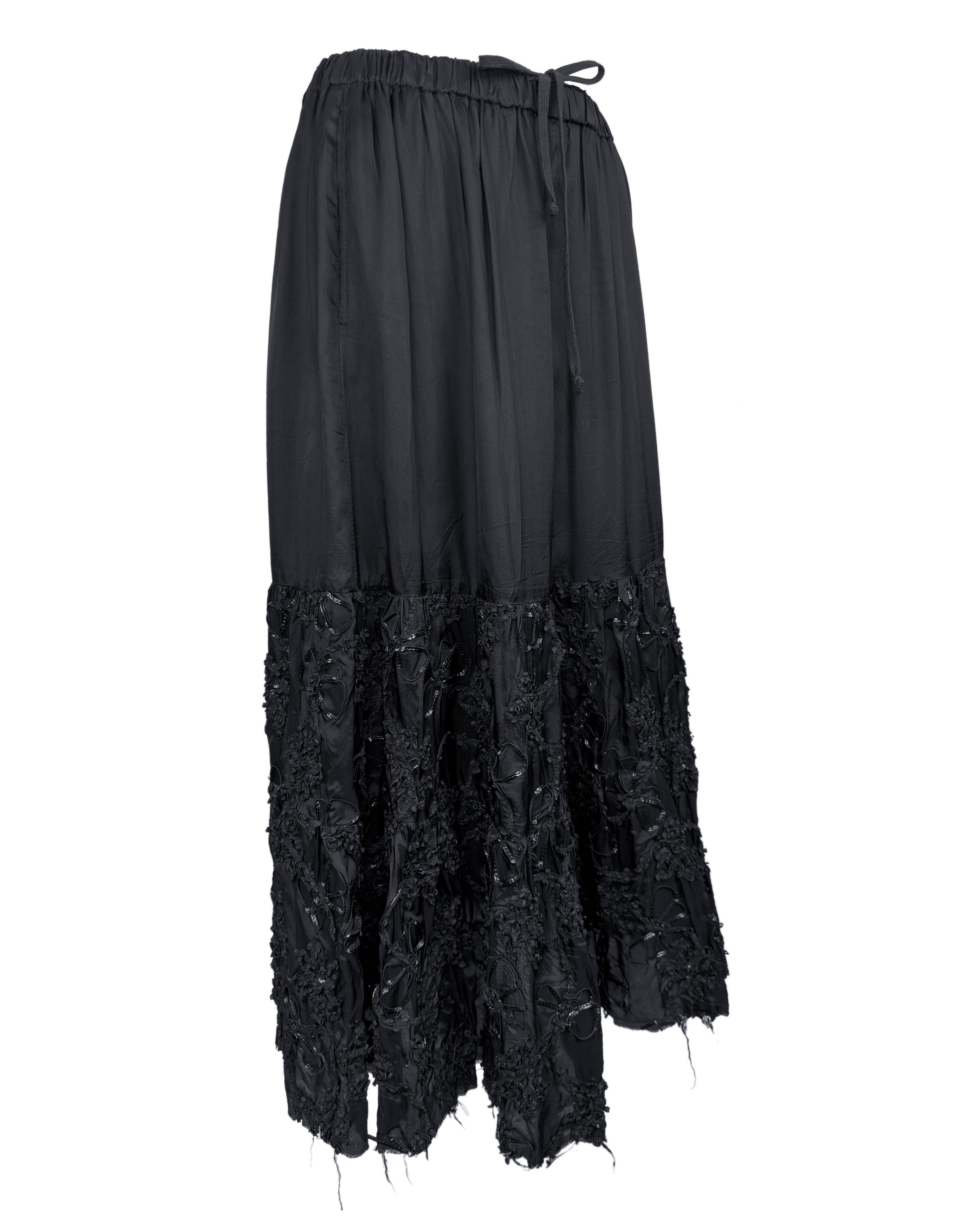 Avant-garde meets tactile romance in this striking black mid 2000's Comme des Garçons skirt. Constructed with Rei Kawakubo’s signature deconstructed aesthetic, the skirt features a loose a-line silhouette crafted from lightweight fabric, gathered at