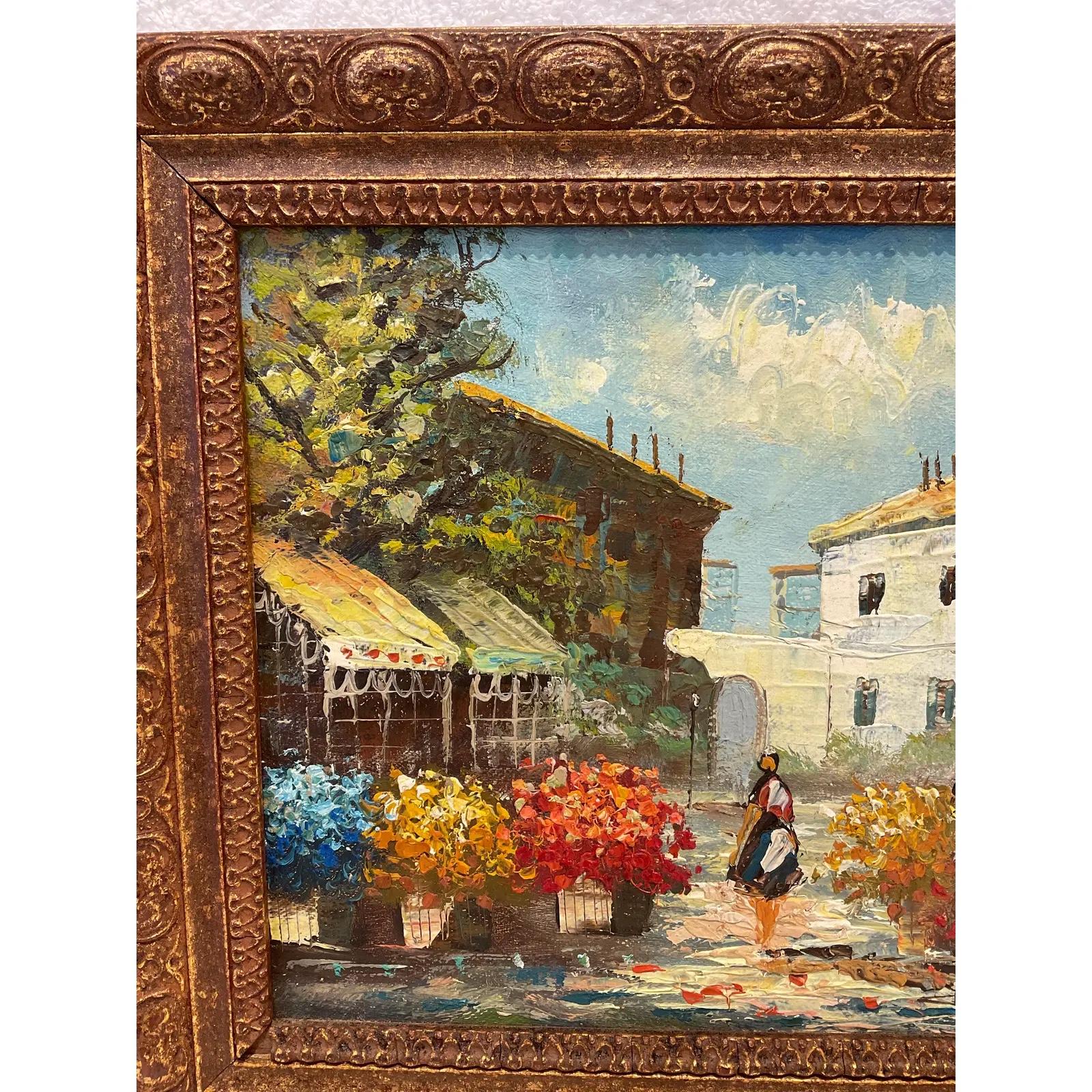 Dieses lebhafte Ölgemälde strotzt nur so vor Persönlichkeit. Zeigt eine Straßenszene mit vielen bunten Blumen, die die Einkaufsstraße säumen. Markisen von Geschäften und alte Architektur im Hintergrund mit schönen blauen Himmel! Ein Ort, den Sie