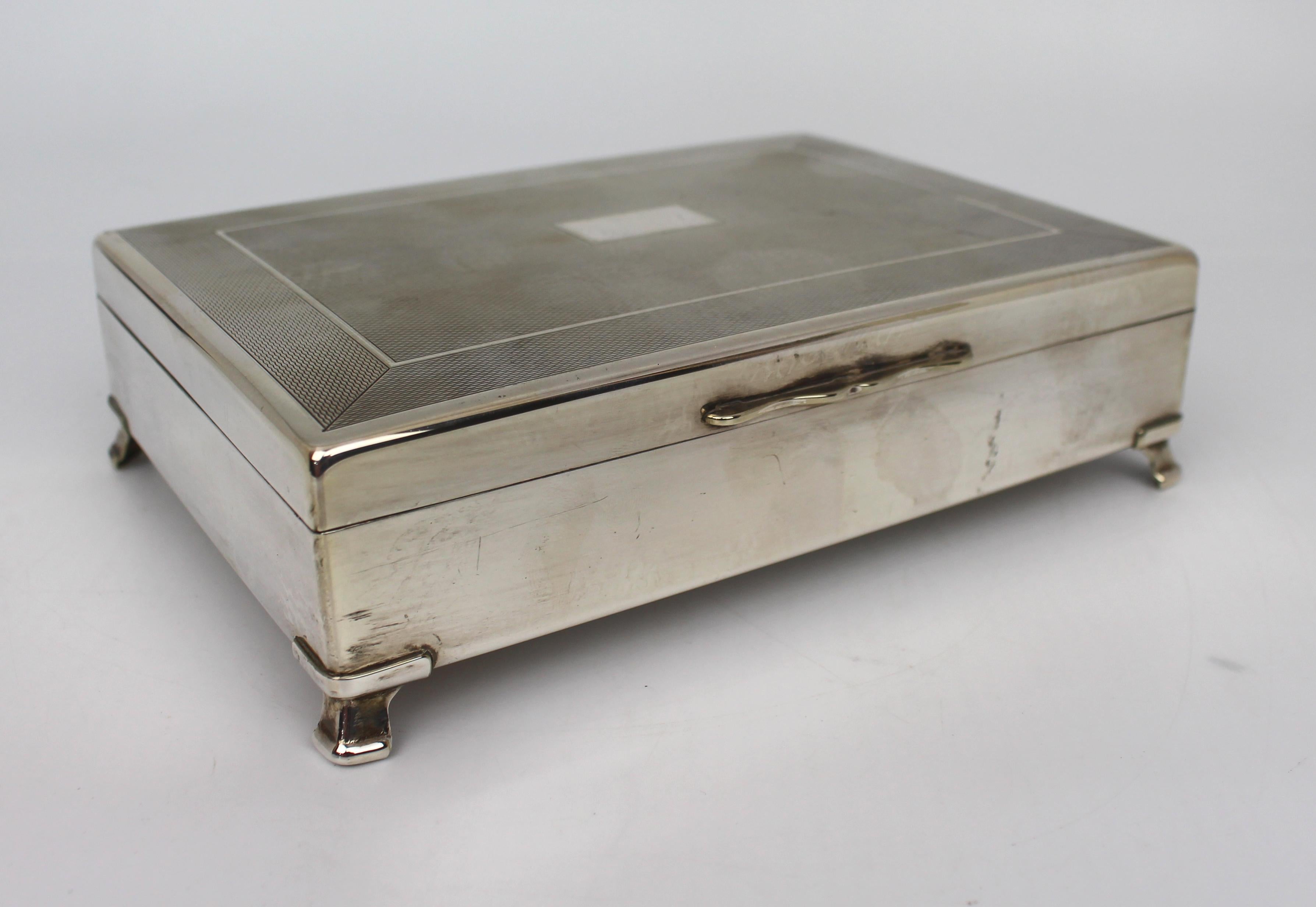 English Aristocrat silver plated footed cigarette box


Mid 20th century, English. Made by Harman Brothers, Birmingham

EPNS, silver plated

Fine cross-hatched, engine-turned engraved hinged lid with blank central cartouche

Cedar wood