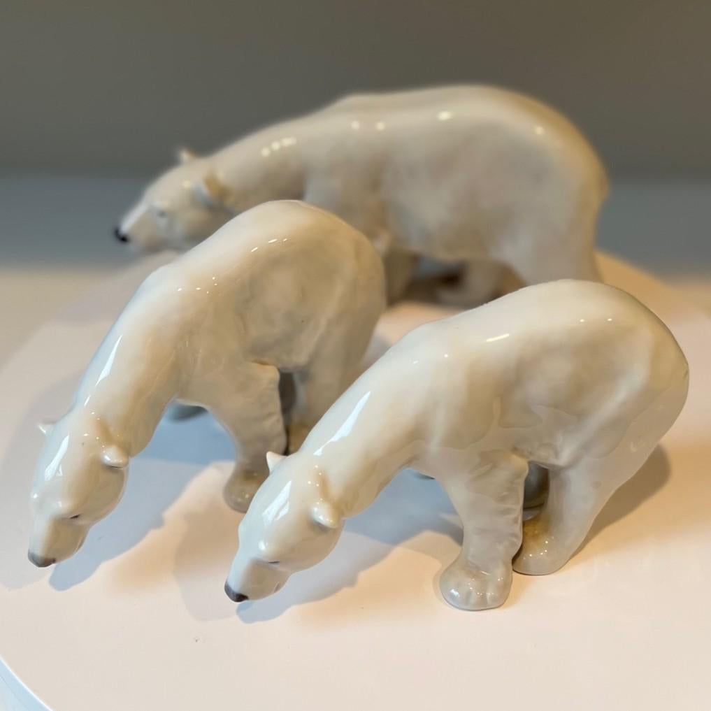 A striking collection of three Royal Copenhagen porcelain polar bear figurines, each showcasing exquisite craftsmanship and elegant Scandinavian design. These hand-painted sculptures capture the naturalistic form and subtle detailing of polar bears