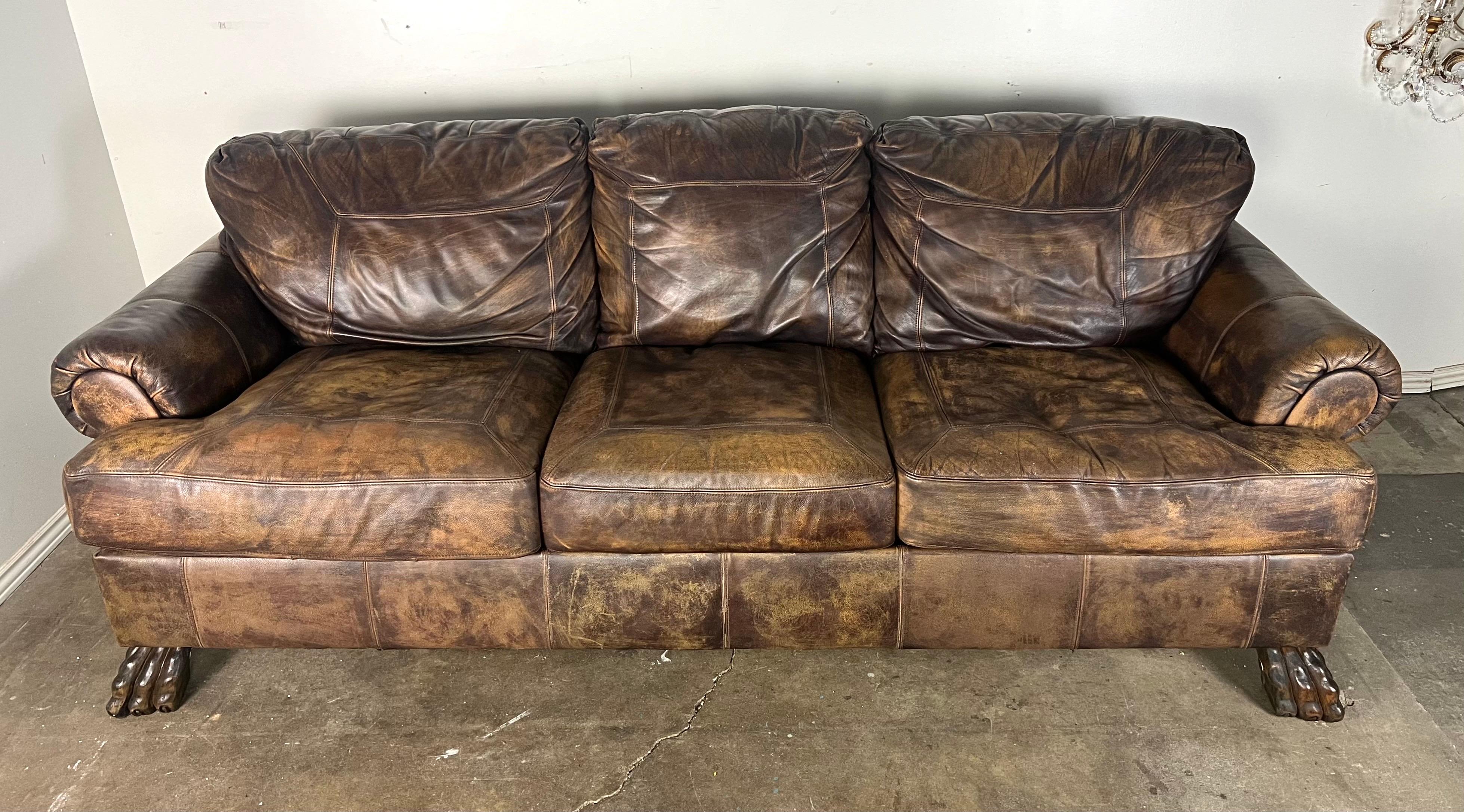 Dieses Sofa ist ein großes Dreisitzer-Sofa im rustikalen Vintage-Stil.  Er ist mit einem braunen Leder bezogen, das ihm ein abgenutztes, gealtertes Aussehen verleiht und seinen Charakter unterstreicht.  Das Sofa ist sowohl an der Sitzfläche als auch