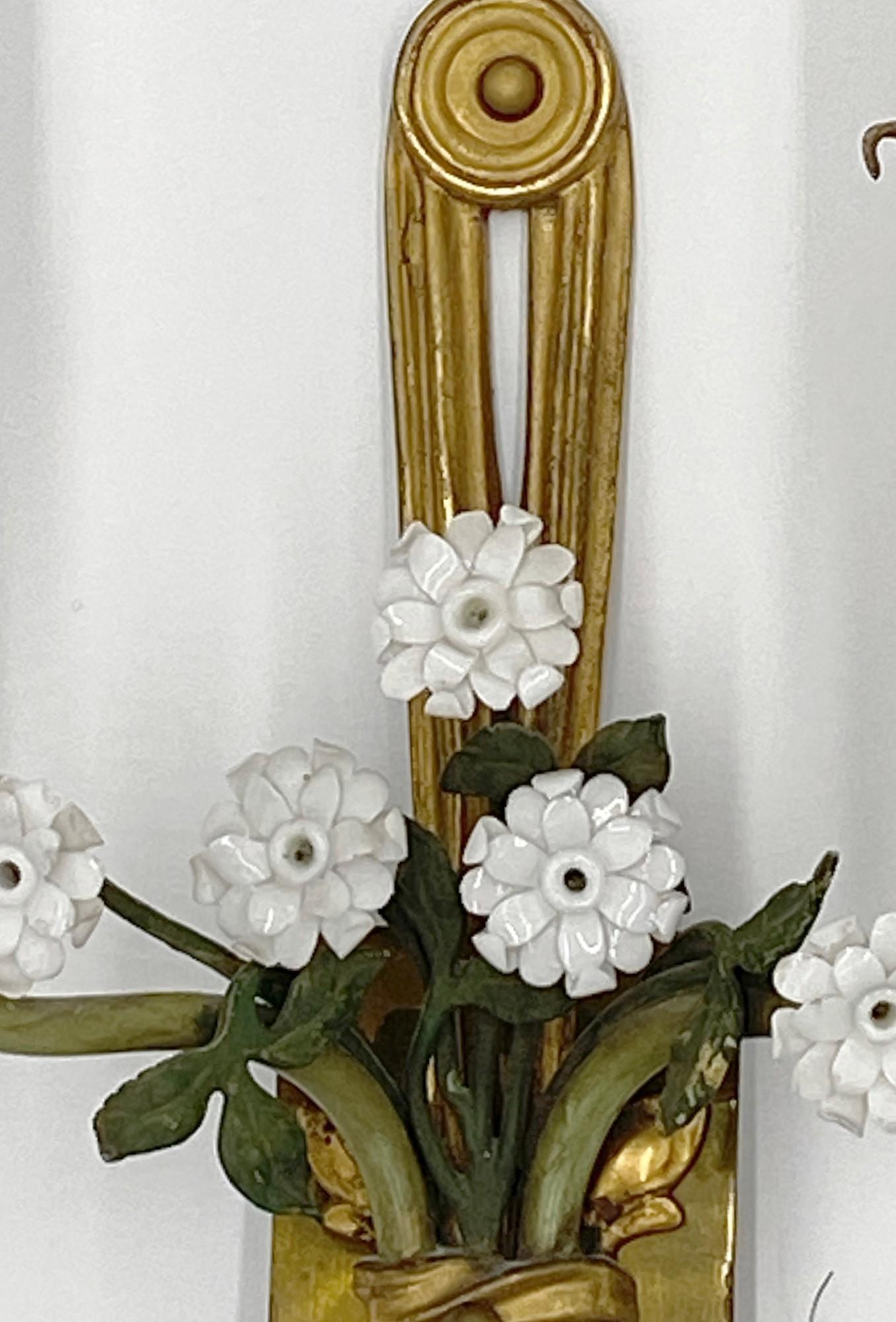 Mid-20th century Italian bronze two arm sconces featuring white porcelain floral flowers details in a green colored vase motif. Priced as a pair. This can be seen at our 333 West 52nd St location in the Theater District West of Manhattan.