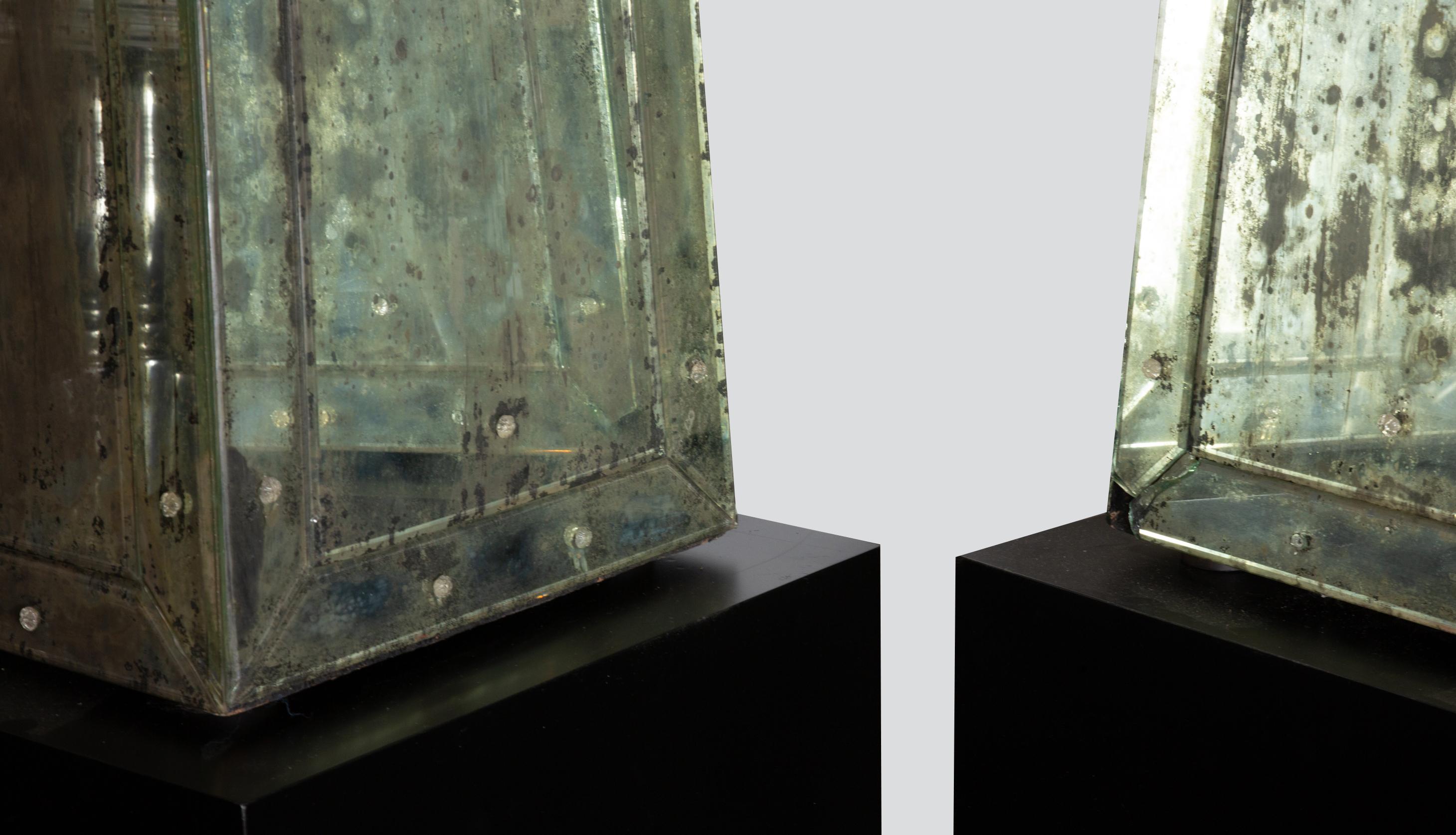 Mid-20th century pair of monumental Continental neoclassical mirrored obelisks raised on painted black wooden cube bases. In the manner of Serge Roche. Obelisks are 67