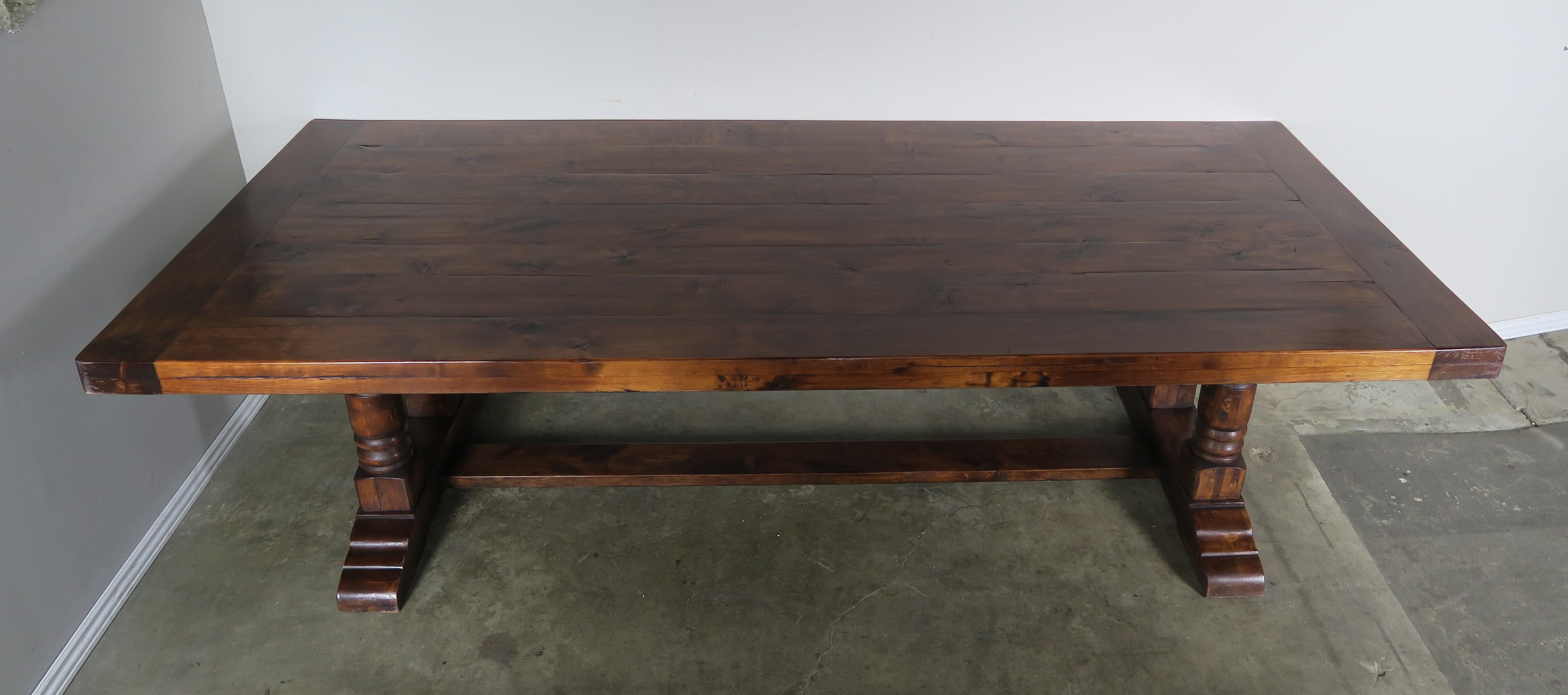Mid-20th century Spanish walnut trestle table standing on two pedestal bases connected by a centre stretcher. This heavy table has a 3