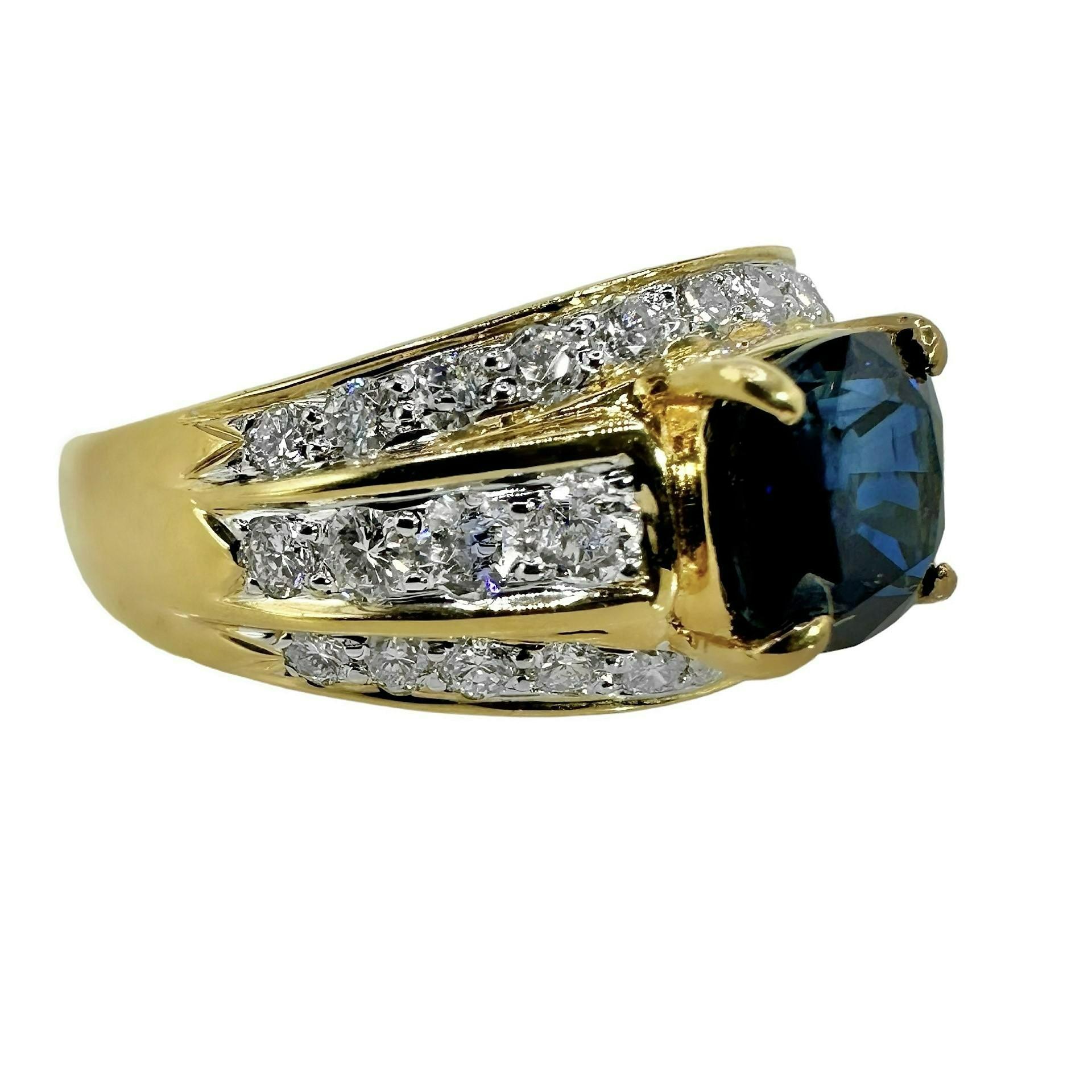 This beautifully crafted 18k yellow gold vintage cocktail ring is set with one cushion cut royal blue natural sapphire, flanked by three lines of brilliant cut diamonds. This stylish design is a classic, and is as beautiful today and it was when it