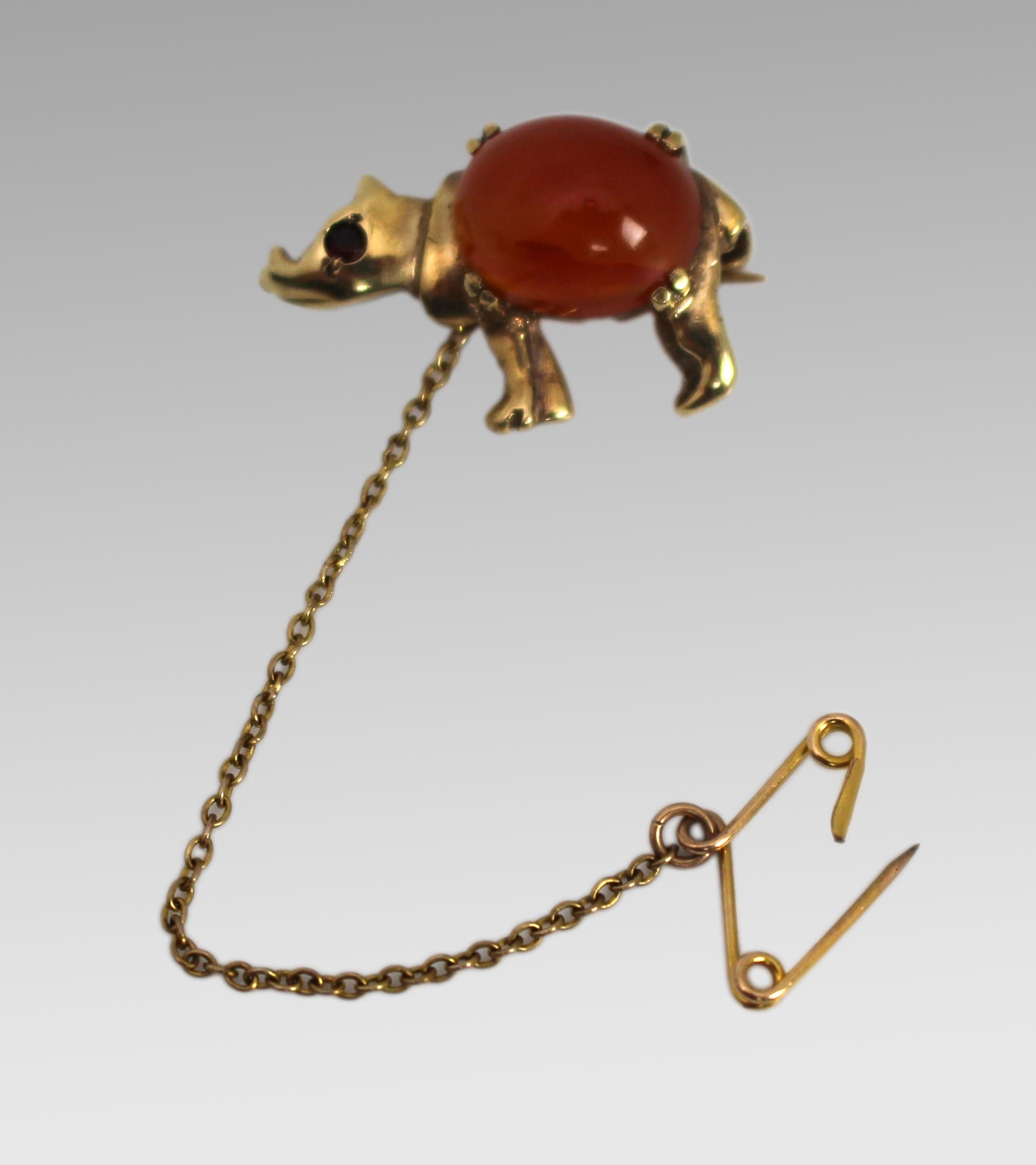 Mid-20th Century 9ct Gold Carnelian and Ruby Rhinoceros Brooch, London 1959

A charming vintage 9ct yellow gold brooch, finely modelled in the form of a rhinoceros. The body is set with a polished cabochon carnelian, accented with a single ruby set