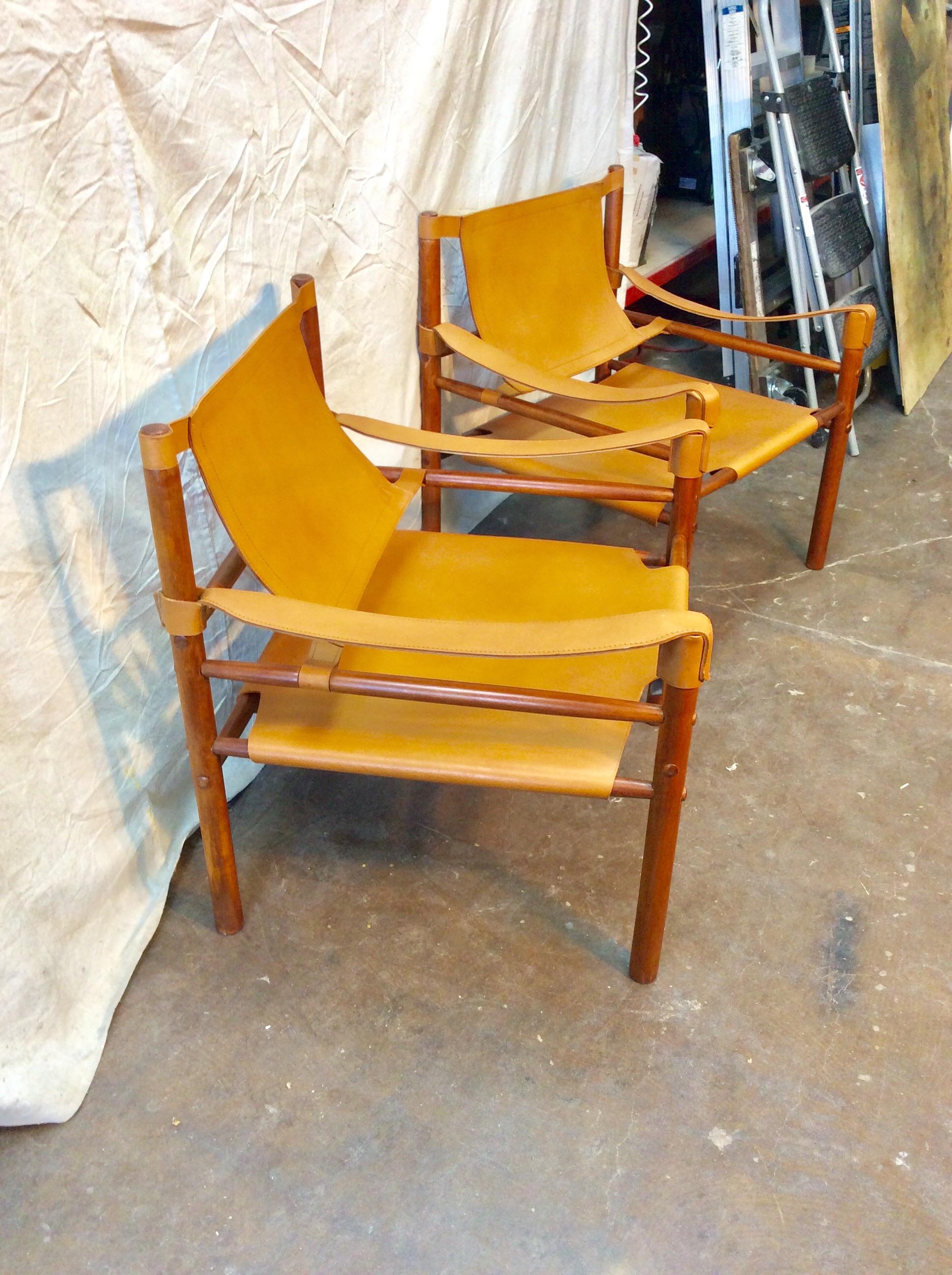 This pair of Mid-Century Modern Leather Sling Safari Chairs were crafted by Argentinian designer Abel Gonzalez in the 1960s. Constructed in a dramatically proportioned layout with straight lines and geometric shapes, the sturdy wood dowled frames