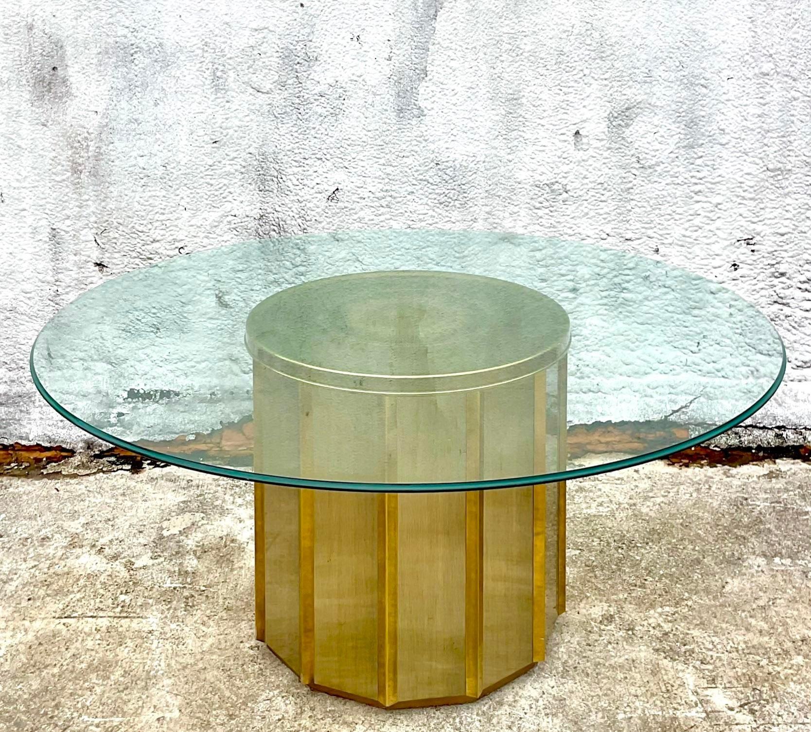 A stunning vintage MCM dining table. Made After the iconic Bernard Rohne for Mastercraft. A chic faceted Brass cylinder under a thick sheet of glass. Acquired from a Palm Beach estate. 