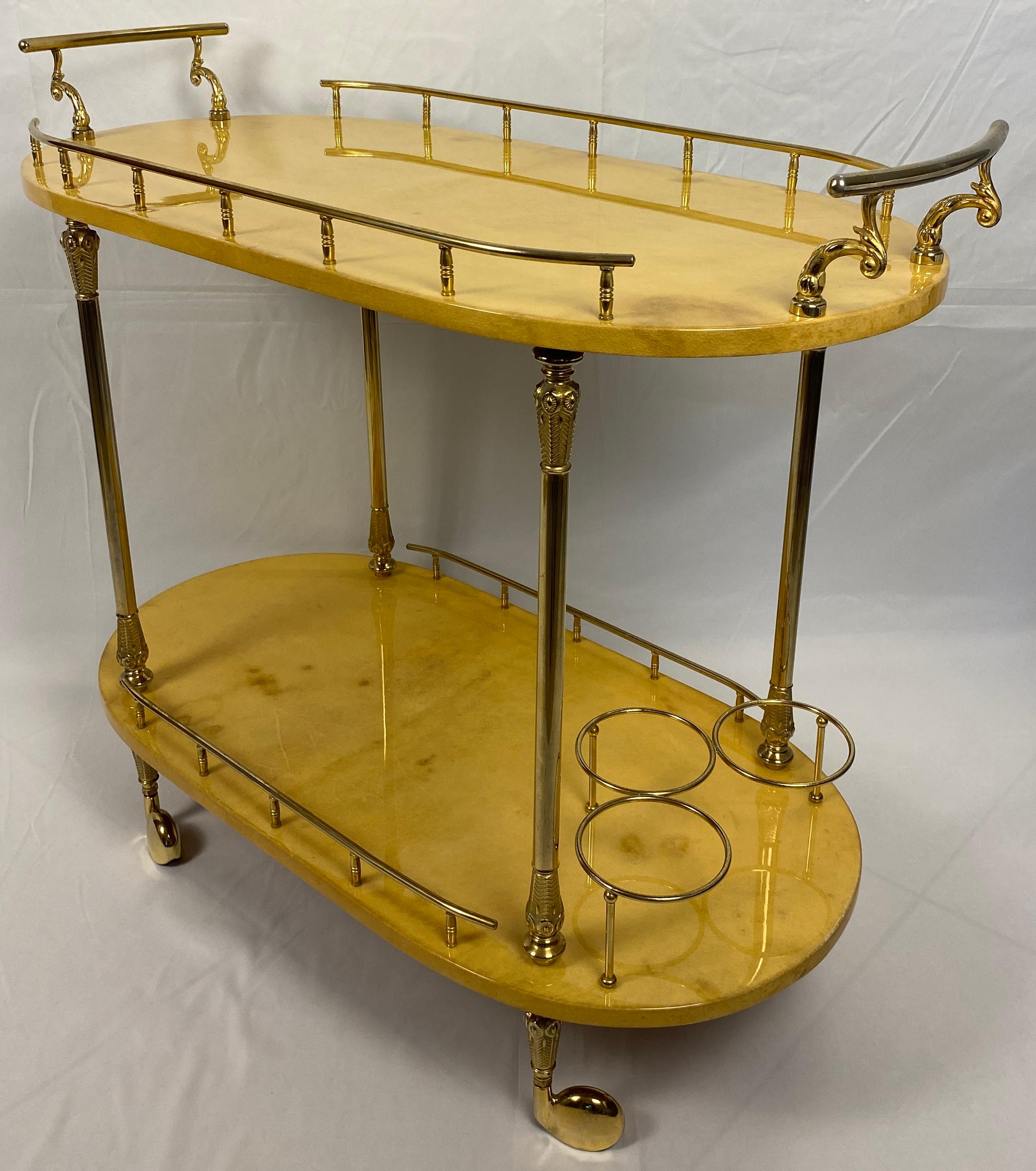 An Aldo Tura Mid-Century Modern Bar Cart/trolley. Two lacquered goatskin tiered shelves with brass mounts on four caster feet. Circa 1960. Label under lower shelf. 

Measures: 33