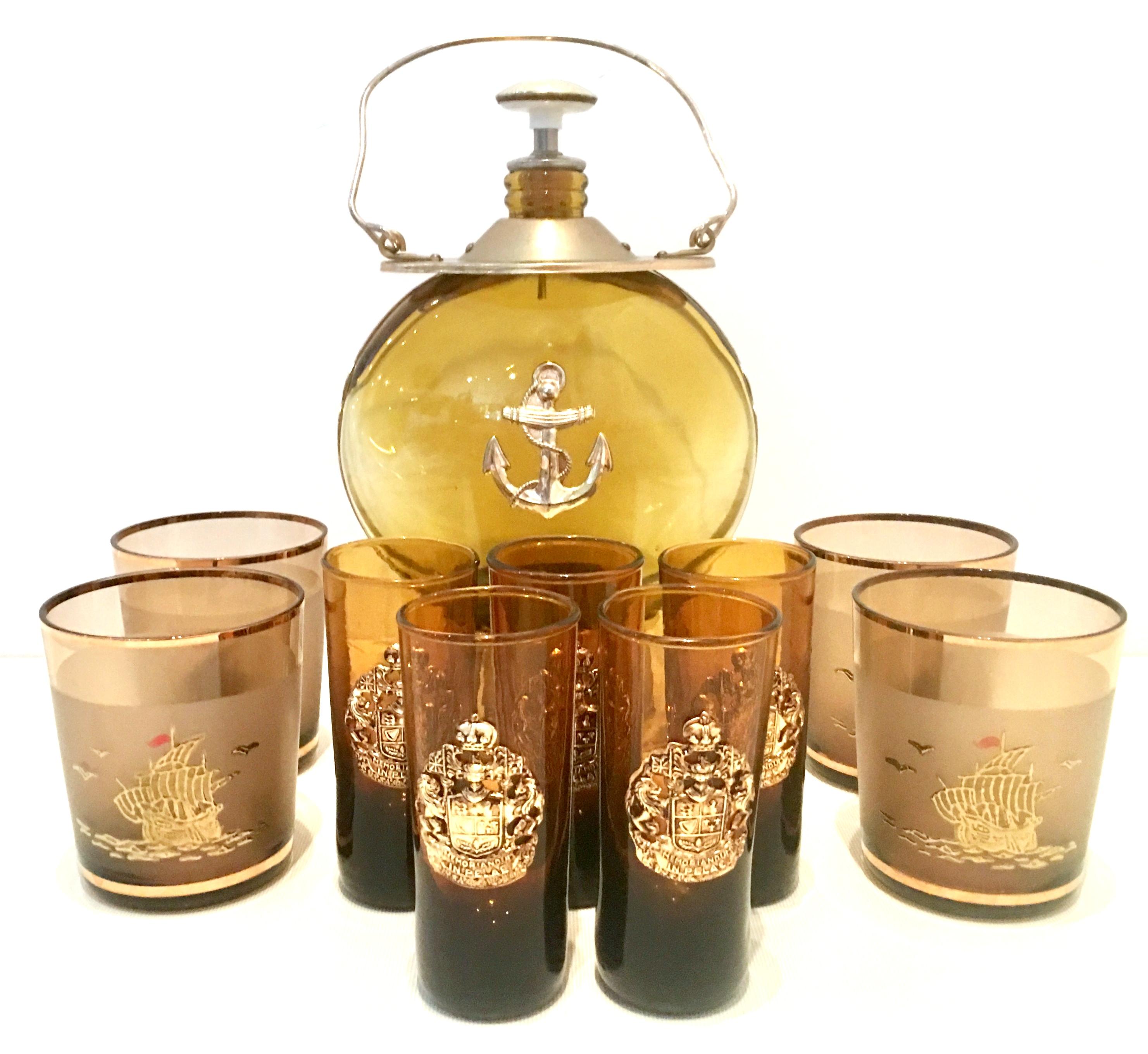 Mid-20th Century amber blown glass, gilt brass and 22-karat gold ten piece drinks set. Set includes, one optic amber and gilt brass hanging lantern style musical liquor decanter., five cordial glasses with applied gilt coat of arms detail and four