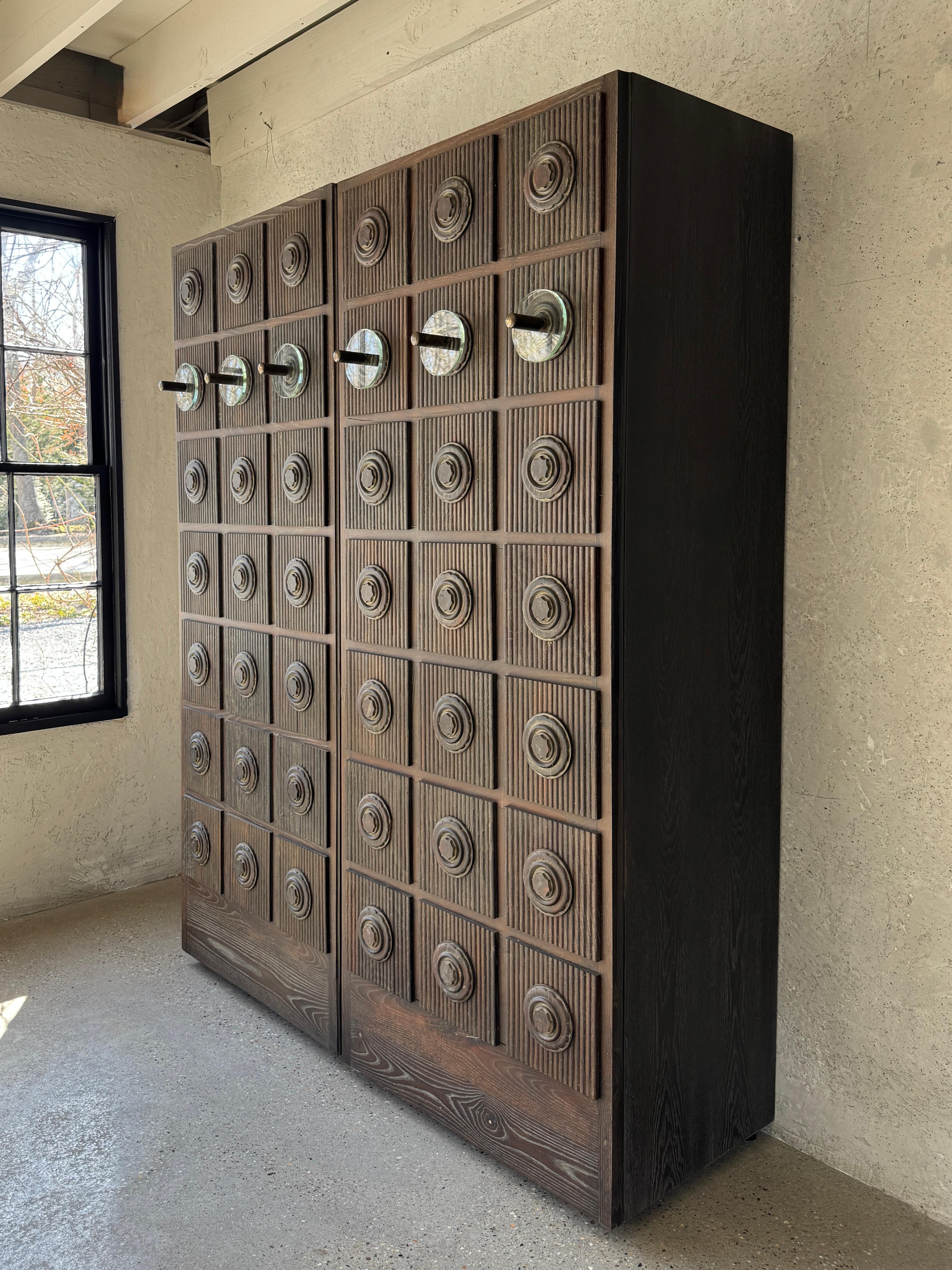 Armoire Brutaliste Américaine du milieu du 20ème siècle en chêne / verre et boutons en bronze
Cette pièce consiste en un arbre d'entrée unique sculpté à la main au milieu du 20e siècle, qui a été démonté et réimaginé en le transformant en armoire.