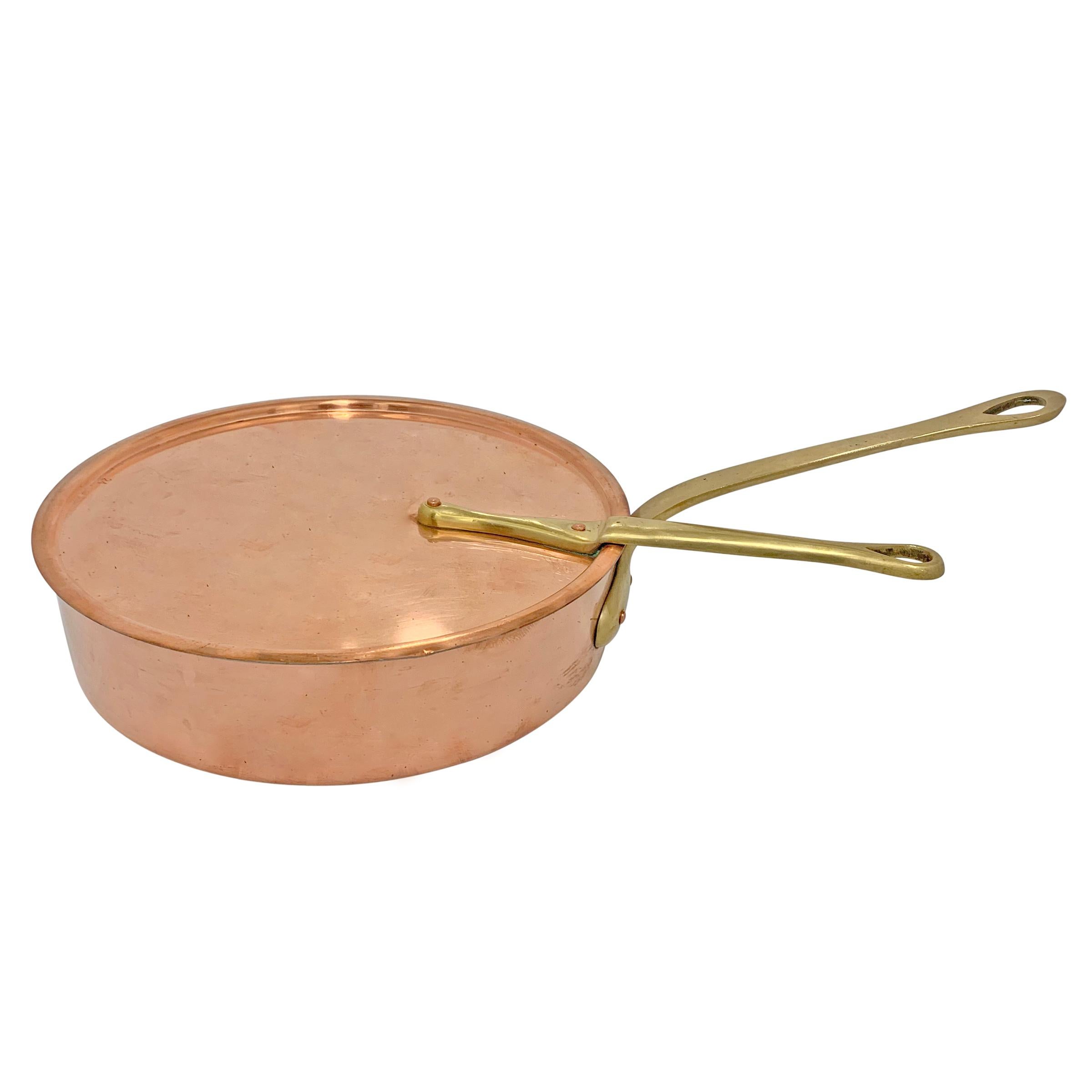 A mid-20th century American 1.4 mm thick copper sauté pan with lid, bronze handles, and a tin lining. Marked 