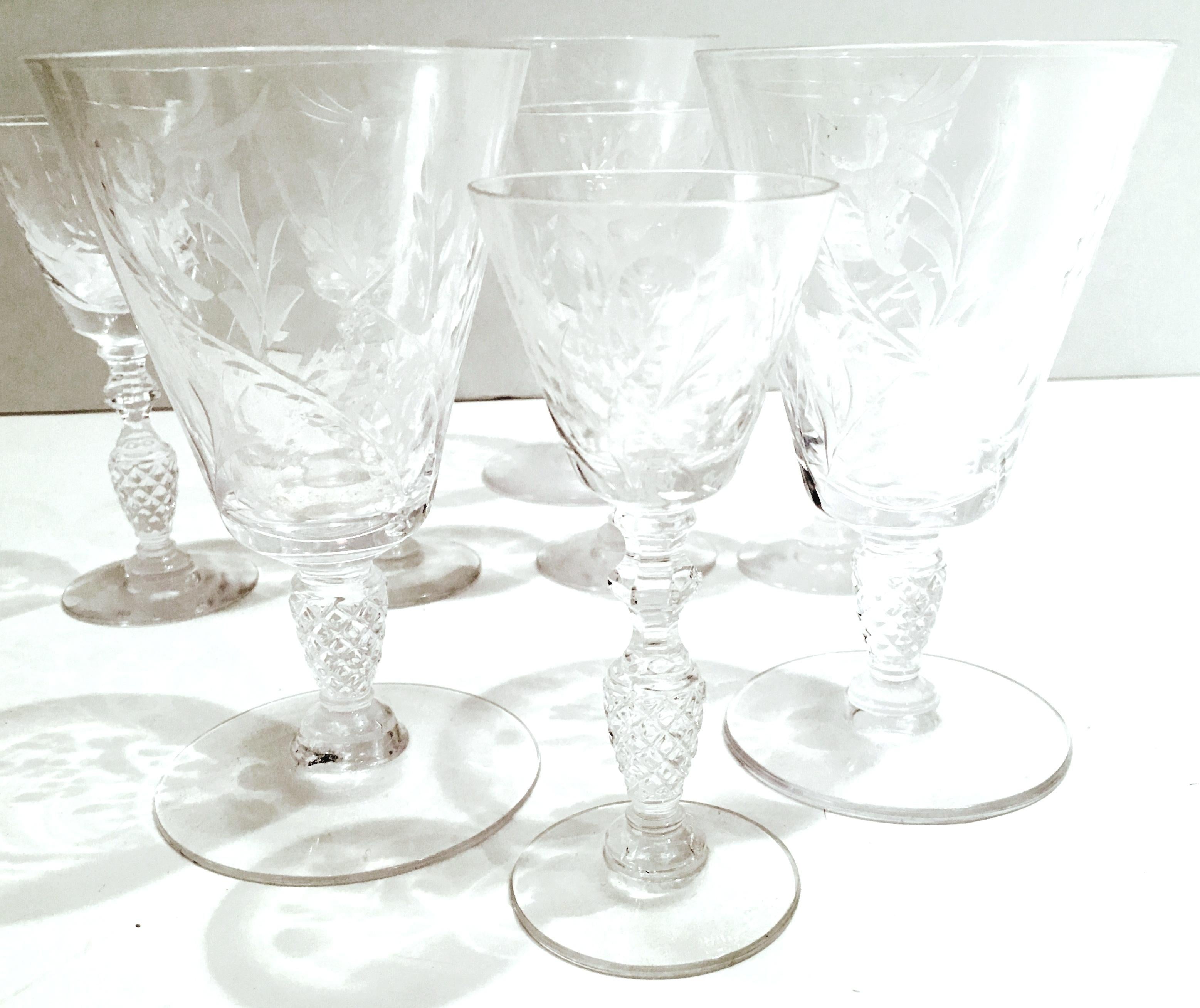 Mid-20th century American cut and etched crystal stem glasses set of eight pieces. Features an etched floral and vine pattern with cut and faceted detail to the stem and a smooth foot. Set includes, five cordial glasses and three goblet