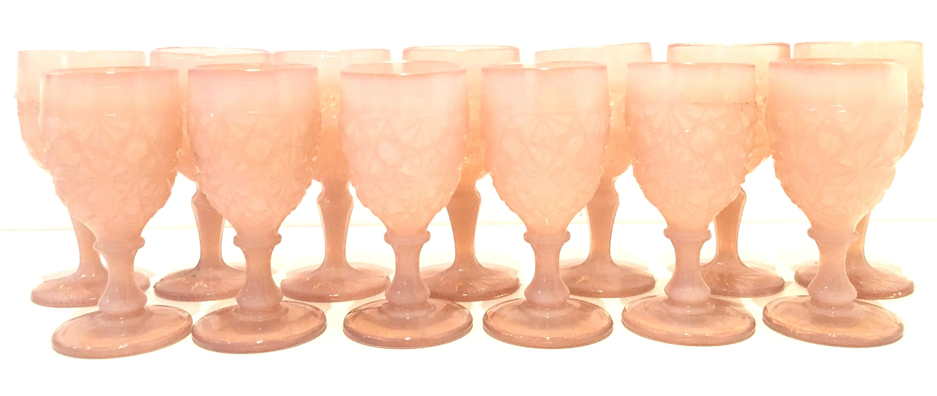 Mid-20th century American cut and faceted pink glass stem drink glasses, set of 13 pieces.
Set includes. Seven tall and six smaller stem glasses. The raised diamond and abstract floral pattern is similar, but not identical between the two