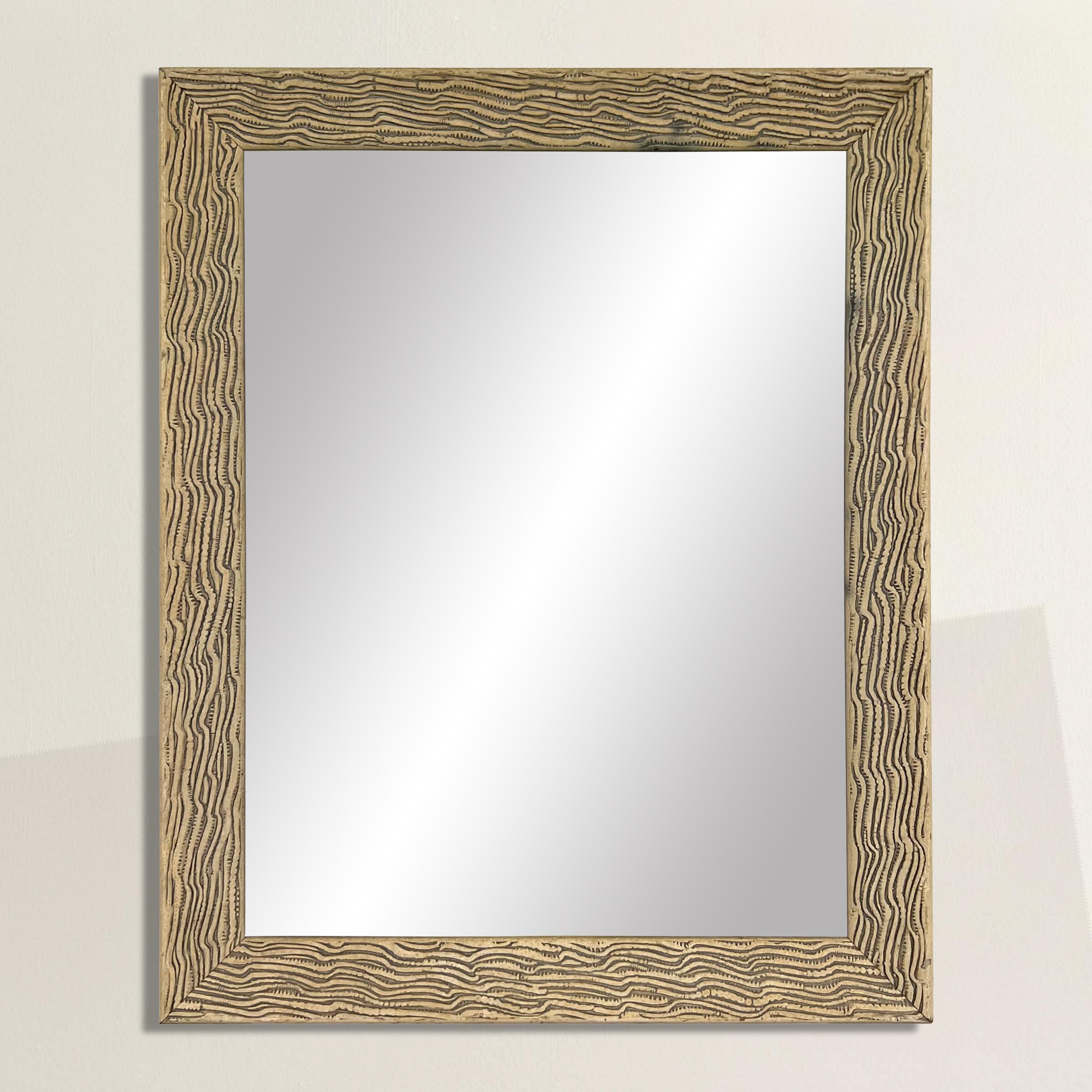 This mid-20th century American mirror exudes rustic charm and chic sophistication with its hand-etched frame, skillfully mimicking the organic patterns of wood grain or deer antler markings. The unique blend of rustic and chic aesthetics makes it a