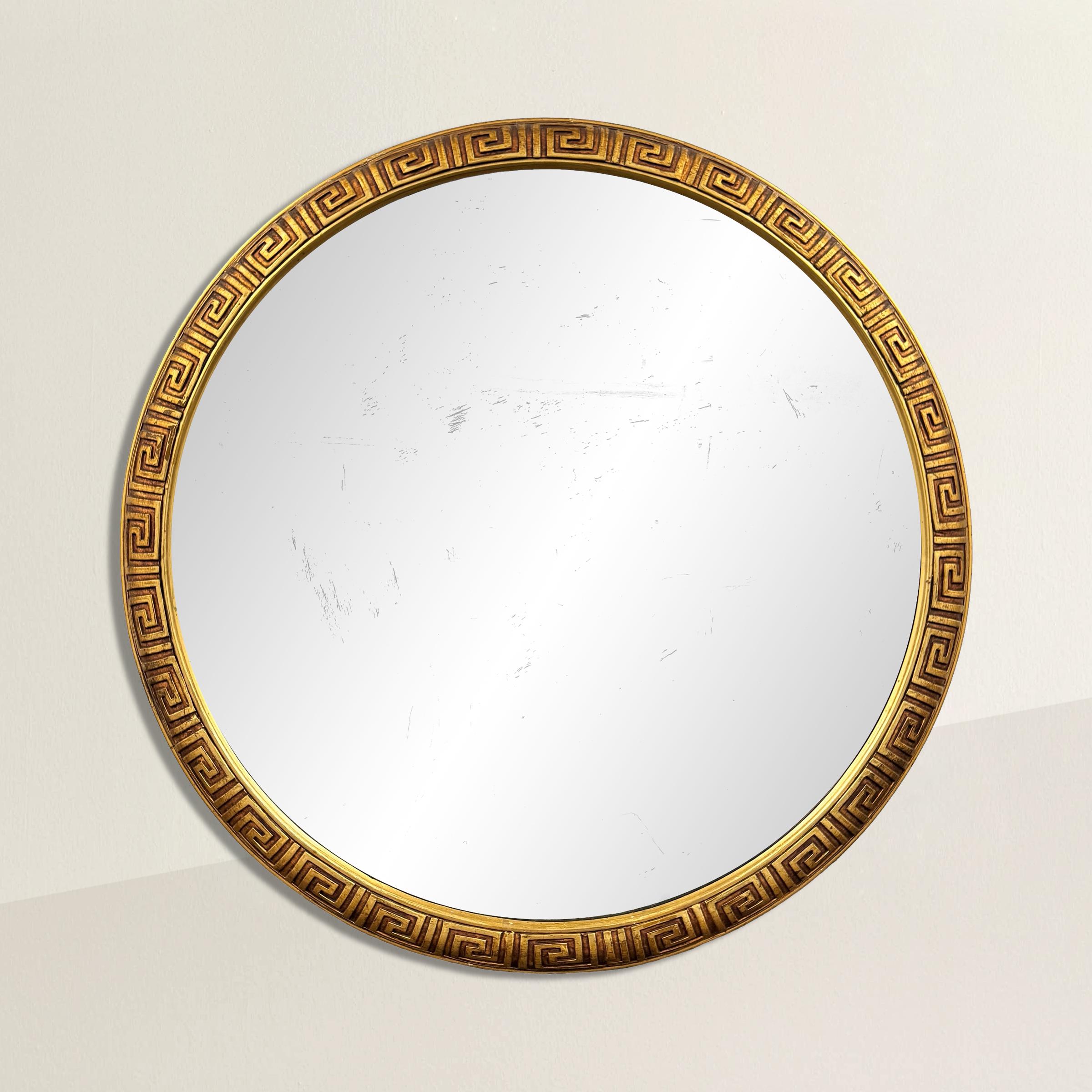 This mid-20th century American round mirror boasts a gilt wood frame intricately carved with a timeless Greek Key pattern. The Greek Key motif, derived from ancient Greek architecture and design, symbolizes unity, continuity, and the eternal flow of
