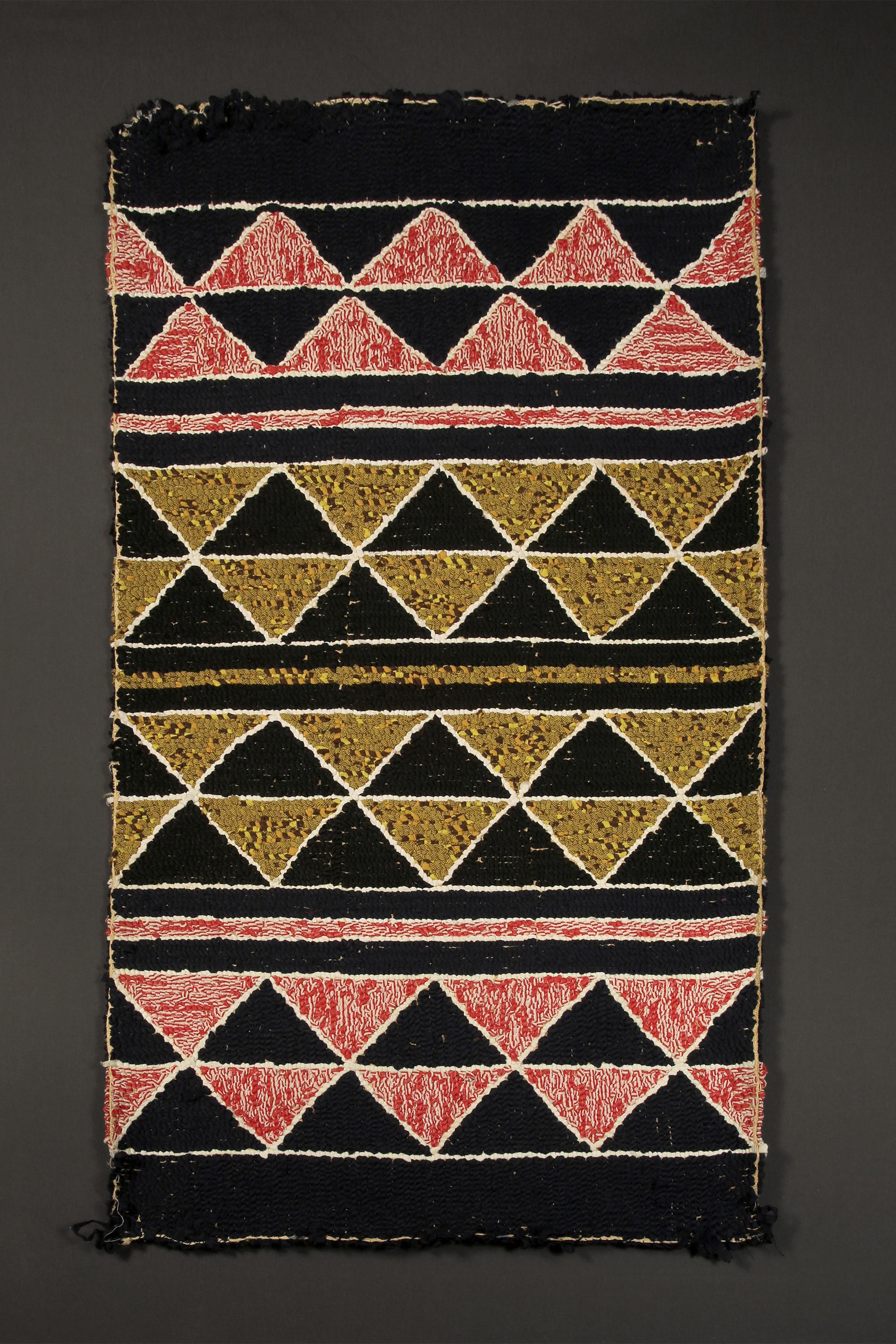 Produced by traditional methods, this American hooked rug features classical repeating geometric patterns of the early mid-century. 

American hooked rug
Reciprocating triangle motif
Mid-20th century (1940s' or earlier) 
Measures: 40 in x 22 in.