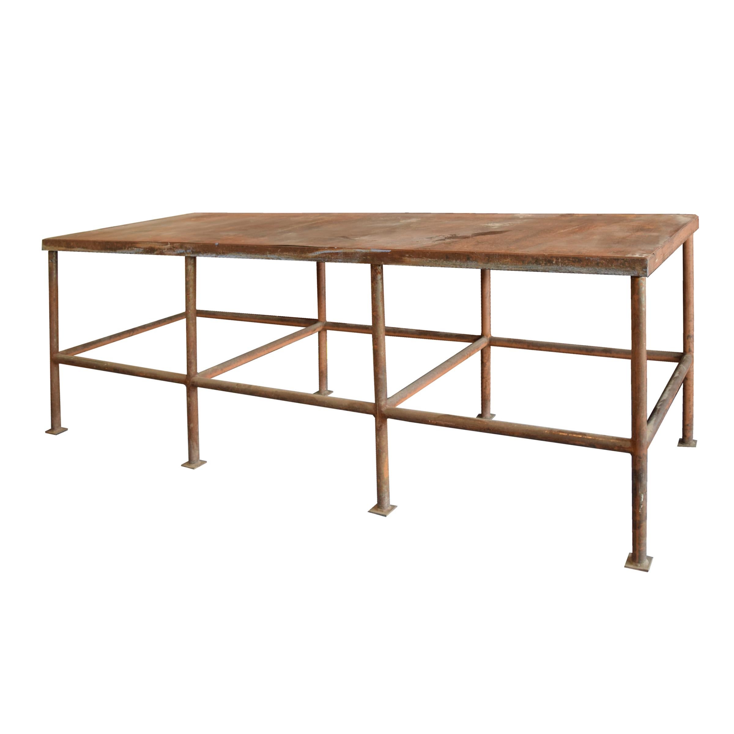 A mid-20th century American industrial steel work table with eight legs.