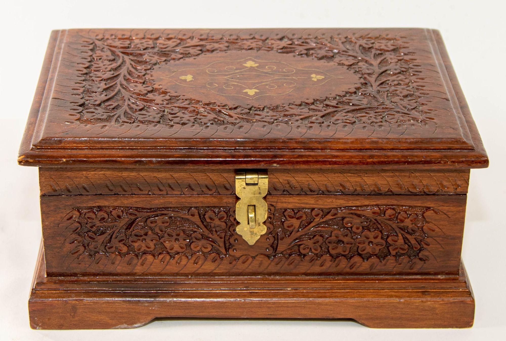 Vintage hand carved wood jewelry trinket storage box with brass inlaid.
Hand-carved large wooden Anglo-Raj jewelry box. Found in Kashmir, India.
Mid 20th century wood box richly decorated overall with arabesques and floral carving. 
Vintage trinket