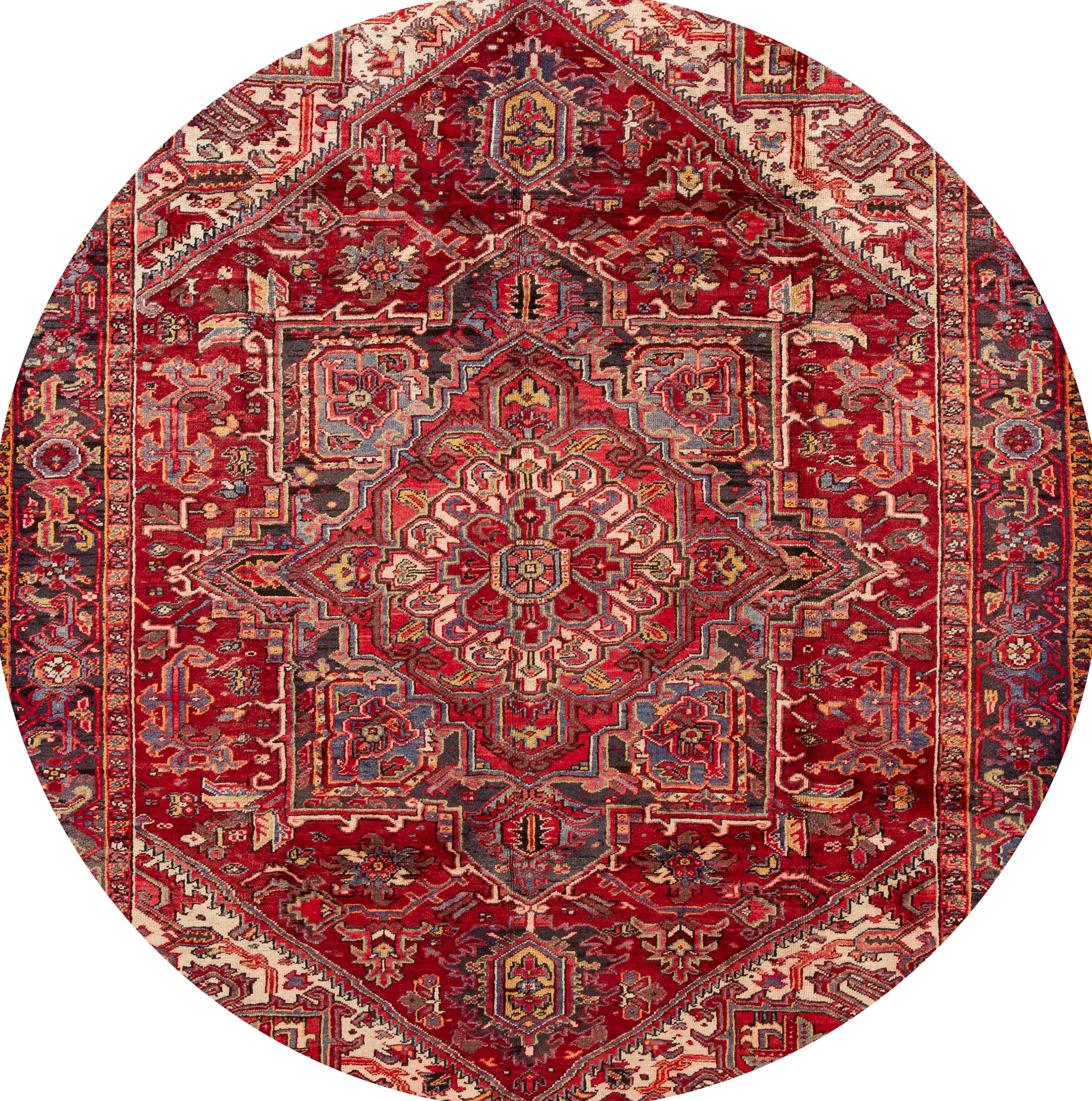 A hand knotted antique Heriz rug with a medallion design on a red field. This rug measures: 7'10
