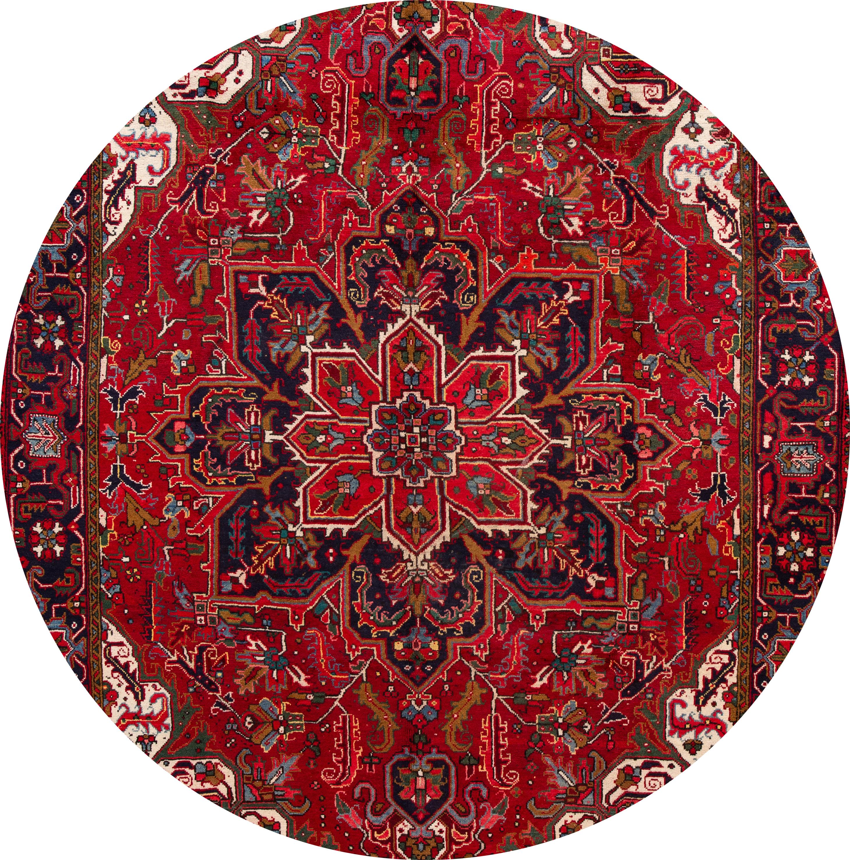 A 20th century antique Heriz rug with an all-over red geometric, medallion motif. This rug measures at 8'1