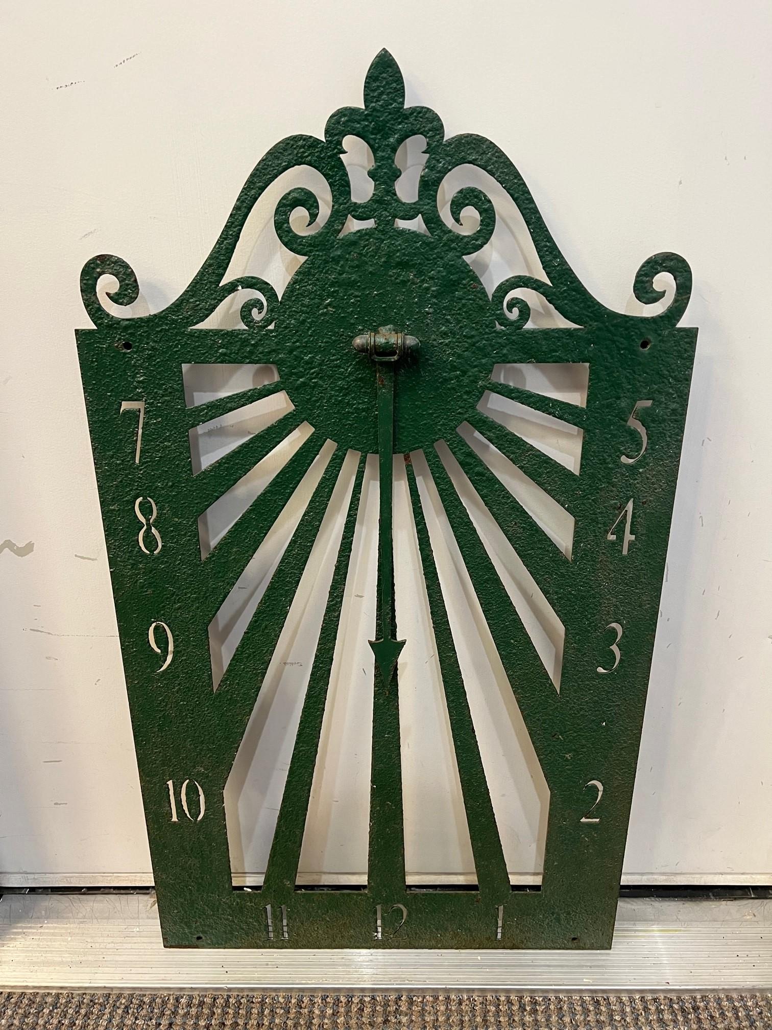 Mid 20th Century antique iron wall sundial with a nice weathered paint finish. This is an unusual sundial that mounts on a wall facing South to tell the time of day. Hanging in the center of the sundial is an iron arrow known as a Gnomon. The Gnomon