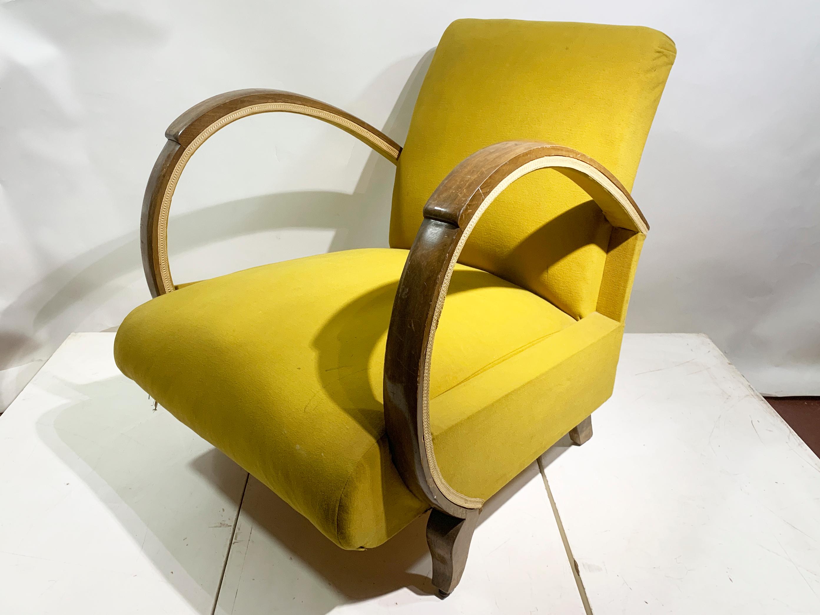 Immergiti nell'eleganza vintage con questa straordinaria poltrona da salotto, testimonianza della sofisticata sensibilità del design dell'epoca Art Déco, che si trasforma in Mid-Century Modern. Questo pezzo emana charme e comfort, rendendolo un