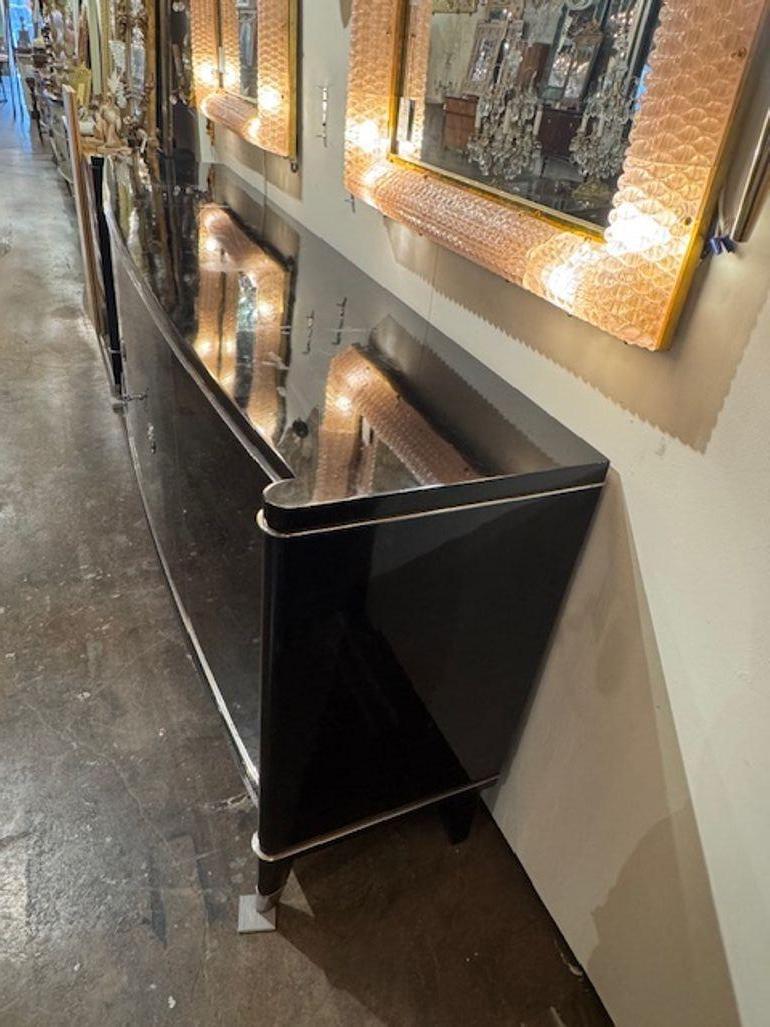 The product is a vintage Art Deco style sideboard in a piano black finish by De Coene Freres of Belgium in the mid-20th century. Featuring a beautiful sleek look that  exudes a luxurious and elegant aesthetic typical of the Art Deco movement. This