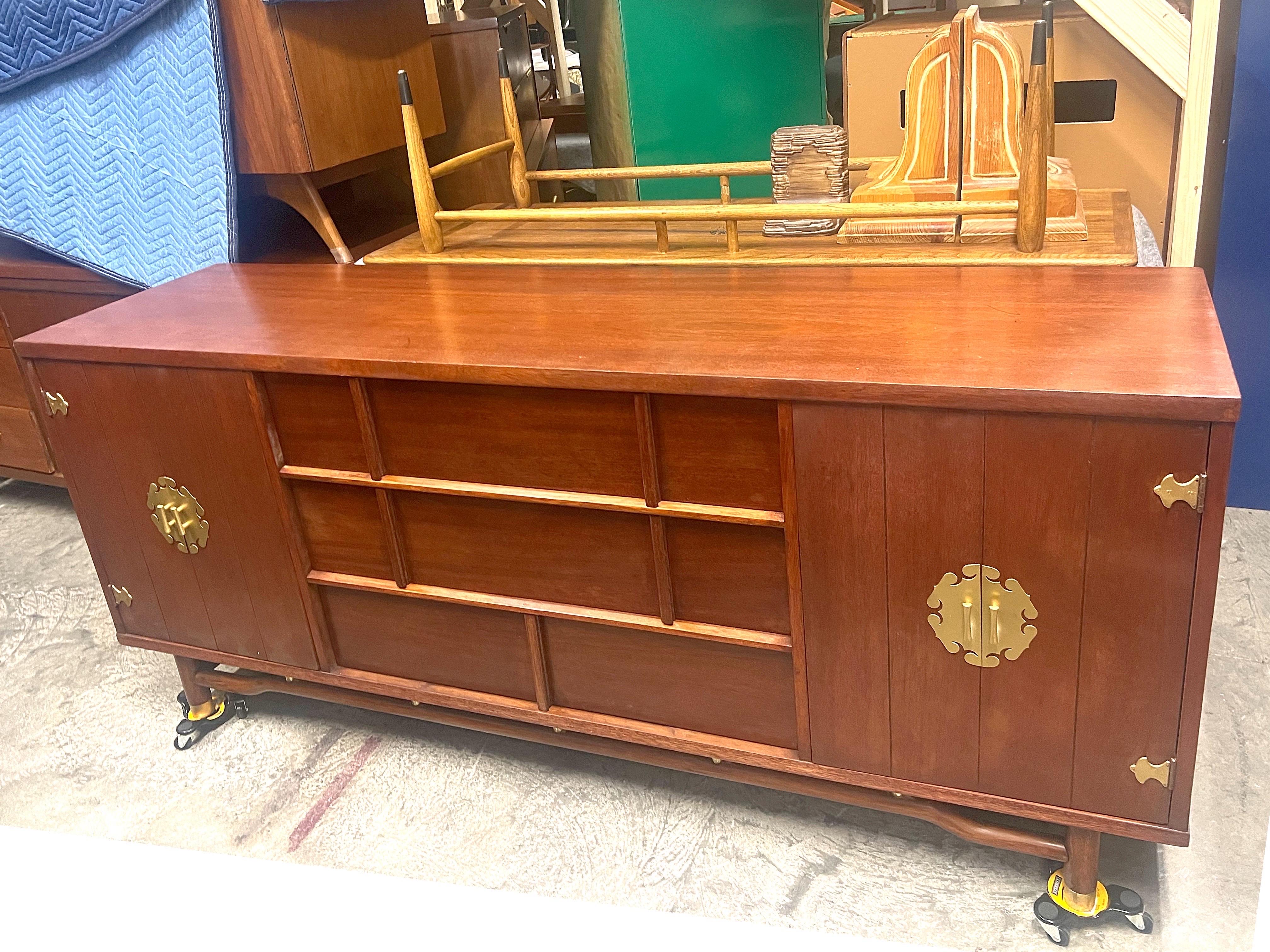Comò triplo asiatico moderno del metà secolo. Profilo minimalista di ispirazione scandinava con un tocco di cineseria. Accentuato da motivi tradizionali cinesi. Medaglioni dorati intorno ai tiranti. Chiave a forma di pagoda alla base.l, anch'essa