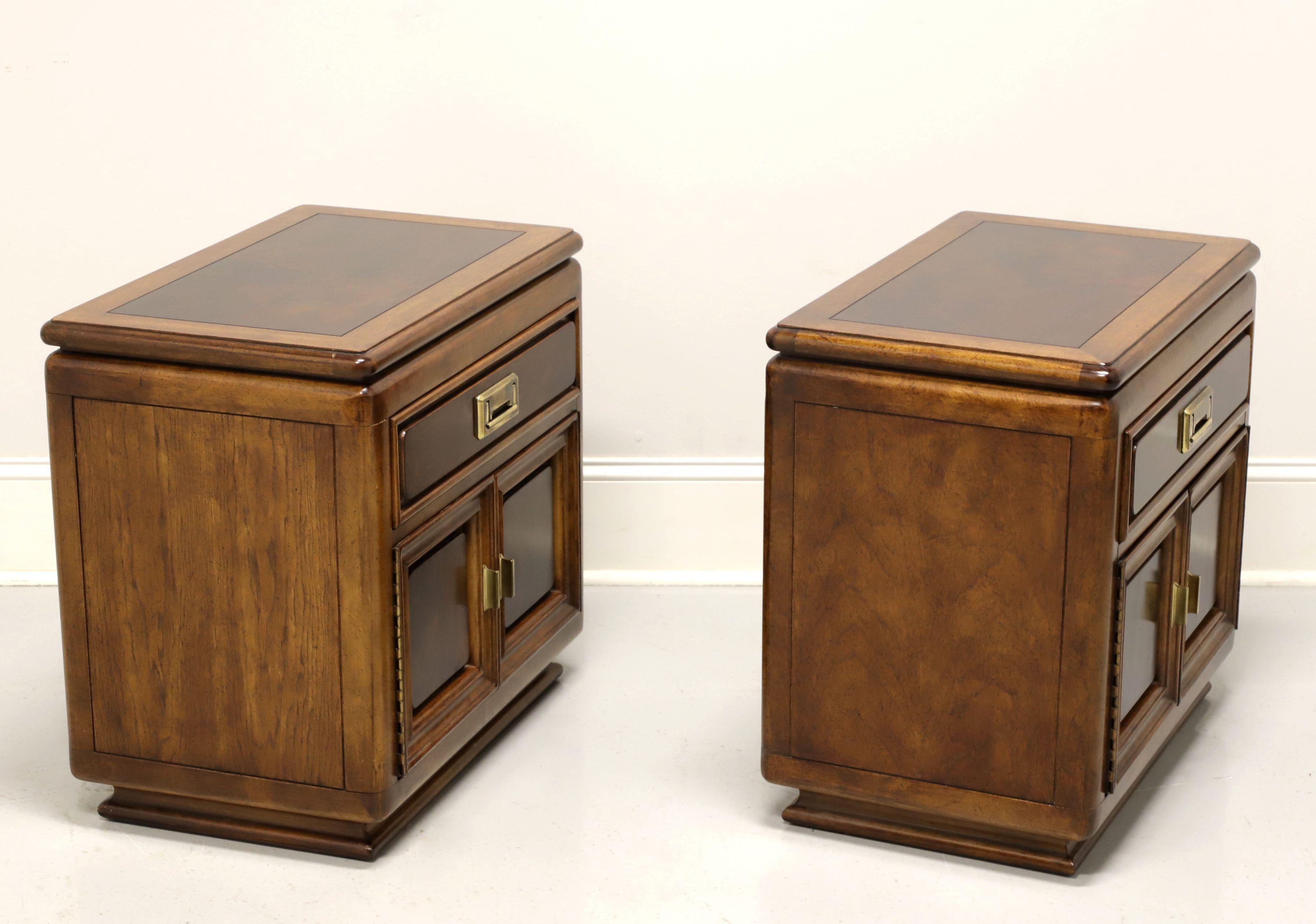A pair of Asian style nightstands by Unique Furniture. Nutwood with slightly distressed finish, burlwood to top, drawer & door fronts, and brass hardware. Features one drawer of dovetail construction over a cabinet with dual doors revealing an