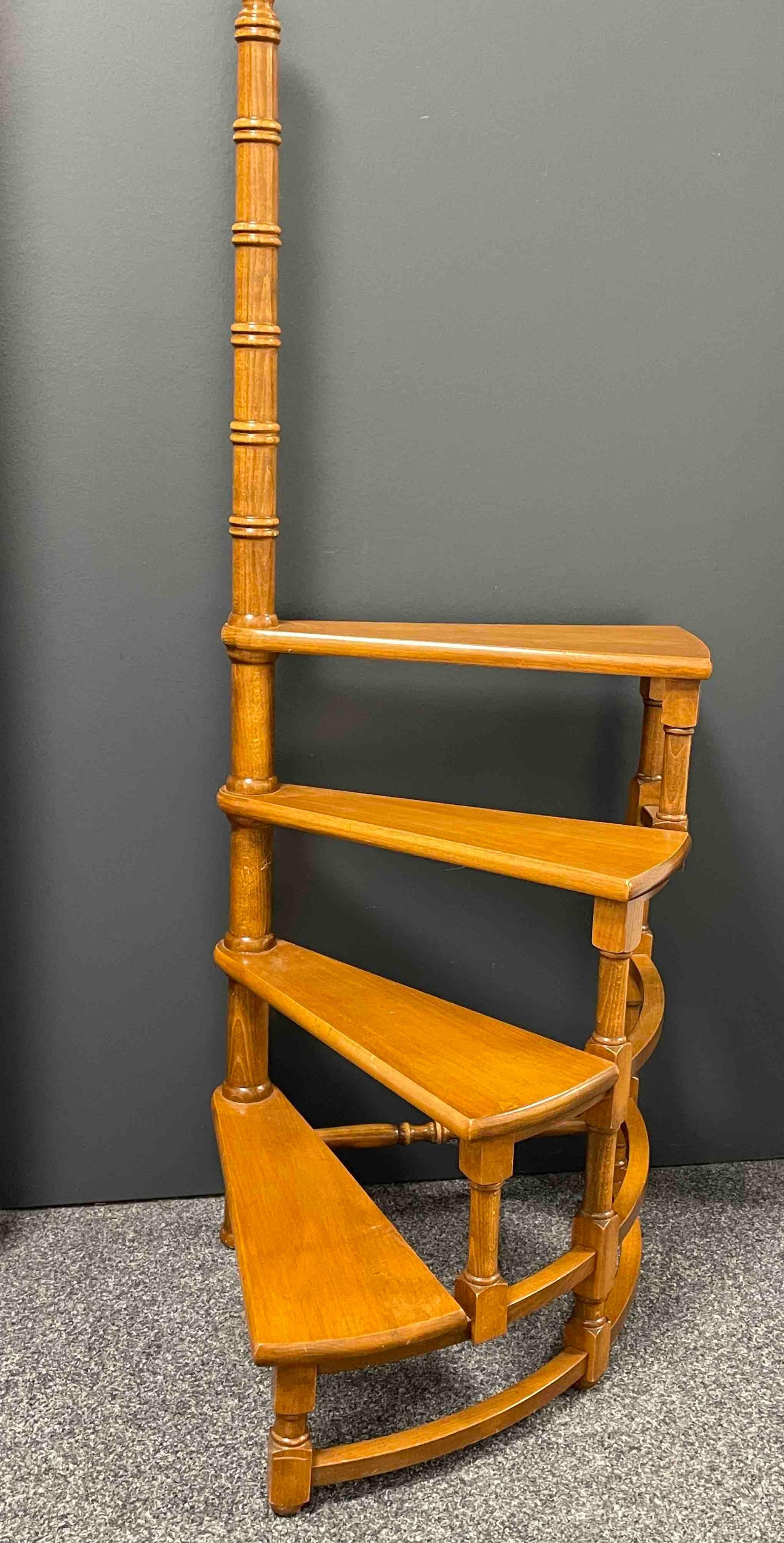 Created in Austria in the 1960s and standing on turned legs, the circular step ladder features four stairs rolled around a turned central post. Versatile and practical, the elegant library essential is in very good used condition with a nice patina.
