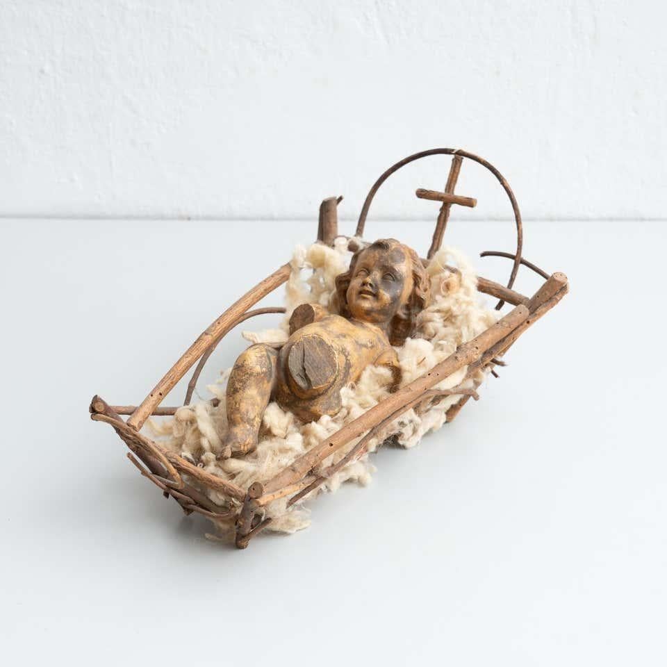 Mid-20th century hand painted baby Jesus figure made of plaster in the cradle.    Made in Barcelona, Spain.    In original condition, with minor wear consistent with age and use, preserving a beautiful patina.    Materials:  Plaster.  Wood.    