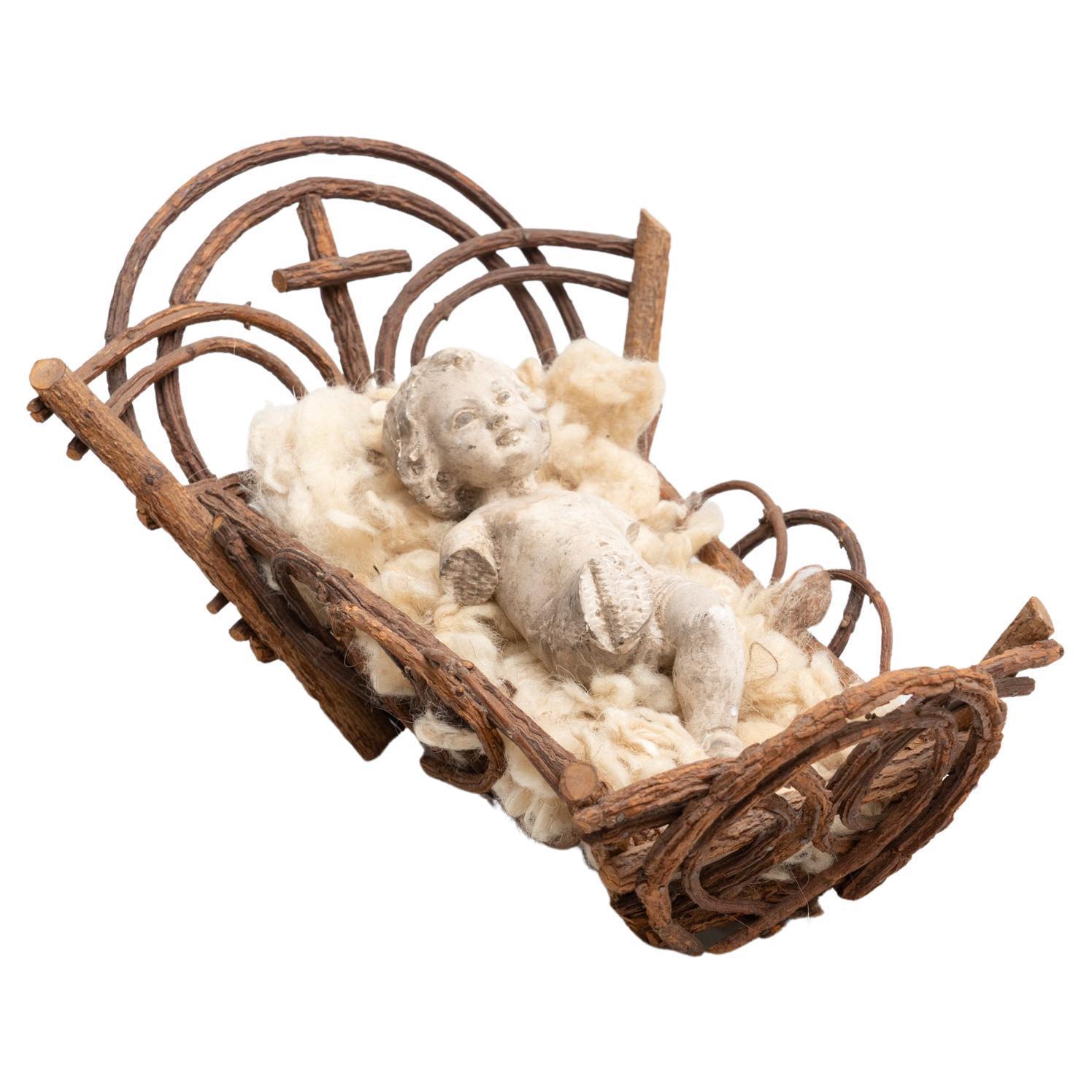 Mid-20th century hand painted baby Jesus figure made of plaster in the cradle.  Made in Barcelona, Spain.    In original condition, with minor wear consistent with age and use, preserving a beautiful patina.    Materials:  Plaster.  Wood.   