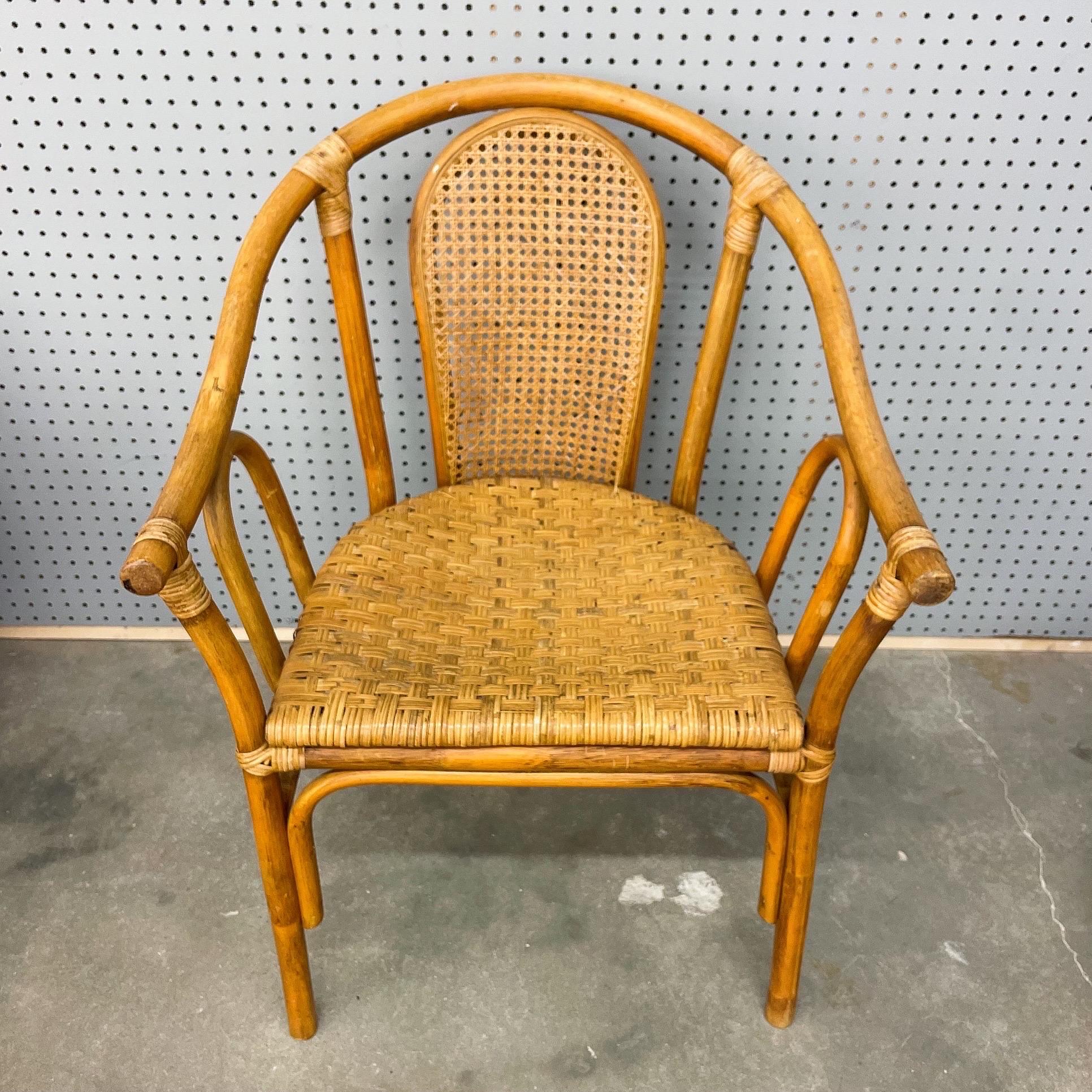 Set of 4 rattan and bamboo barrel-shaped arm chairs feature bow back with cane insert and two-toned finish. Very good condition with minor imperfections consistent with age.