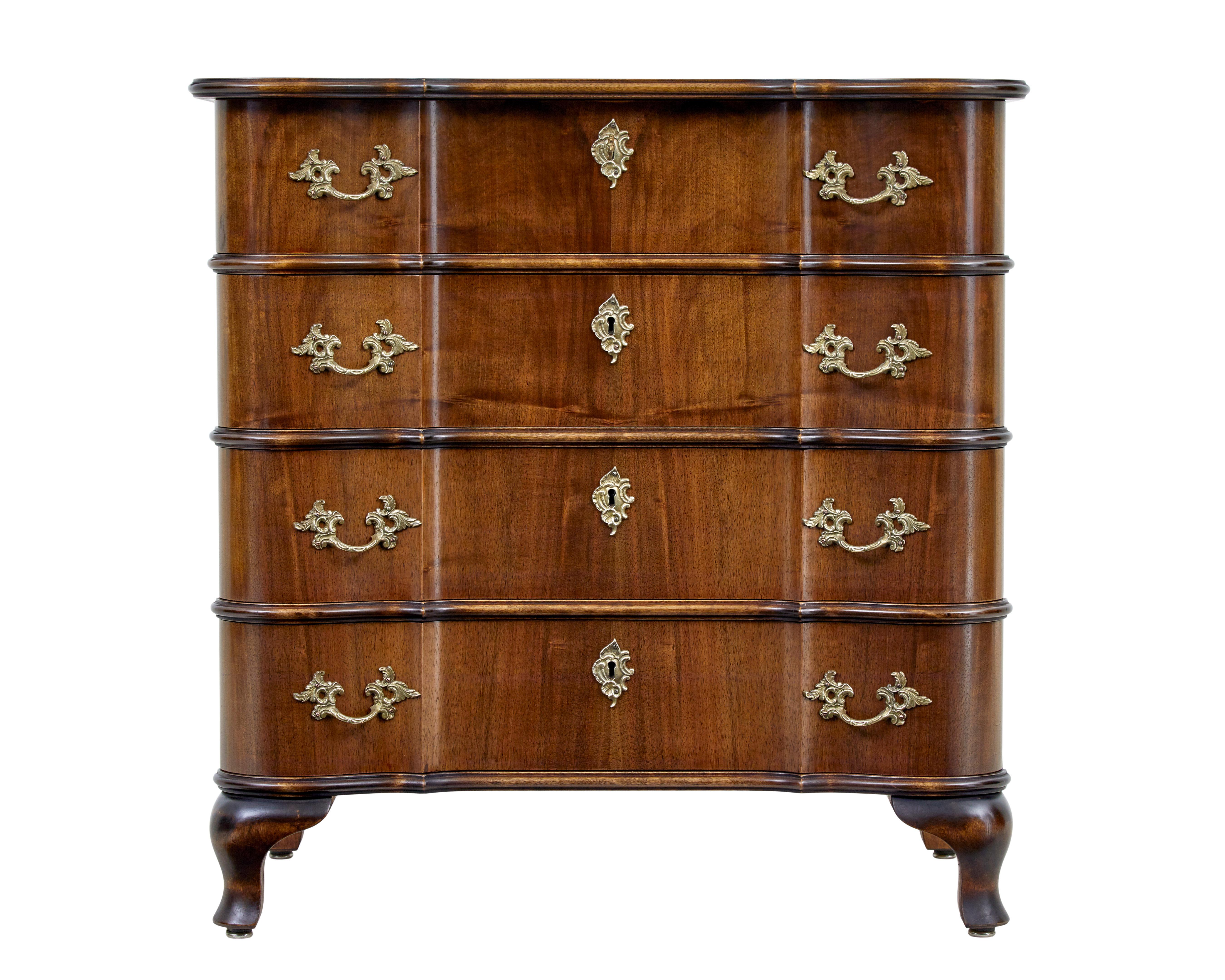 Mid 20th century baroque inspired walnut chest of drawers circa 1950.

Elegant serpentine shaped walnut commode of petit proportions.

4 drawer chest with shaped drawer fronts and top.  Fitted with ornate brass handles and escutheon
