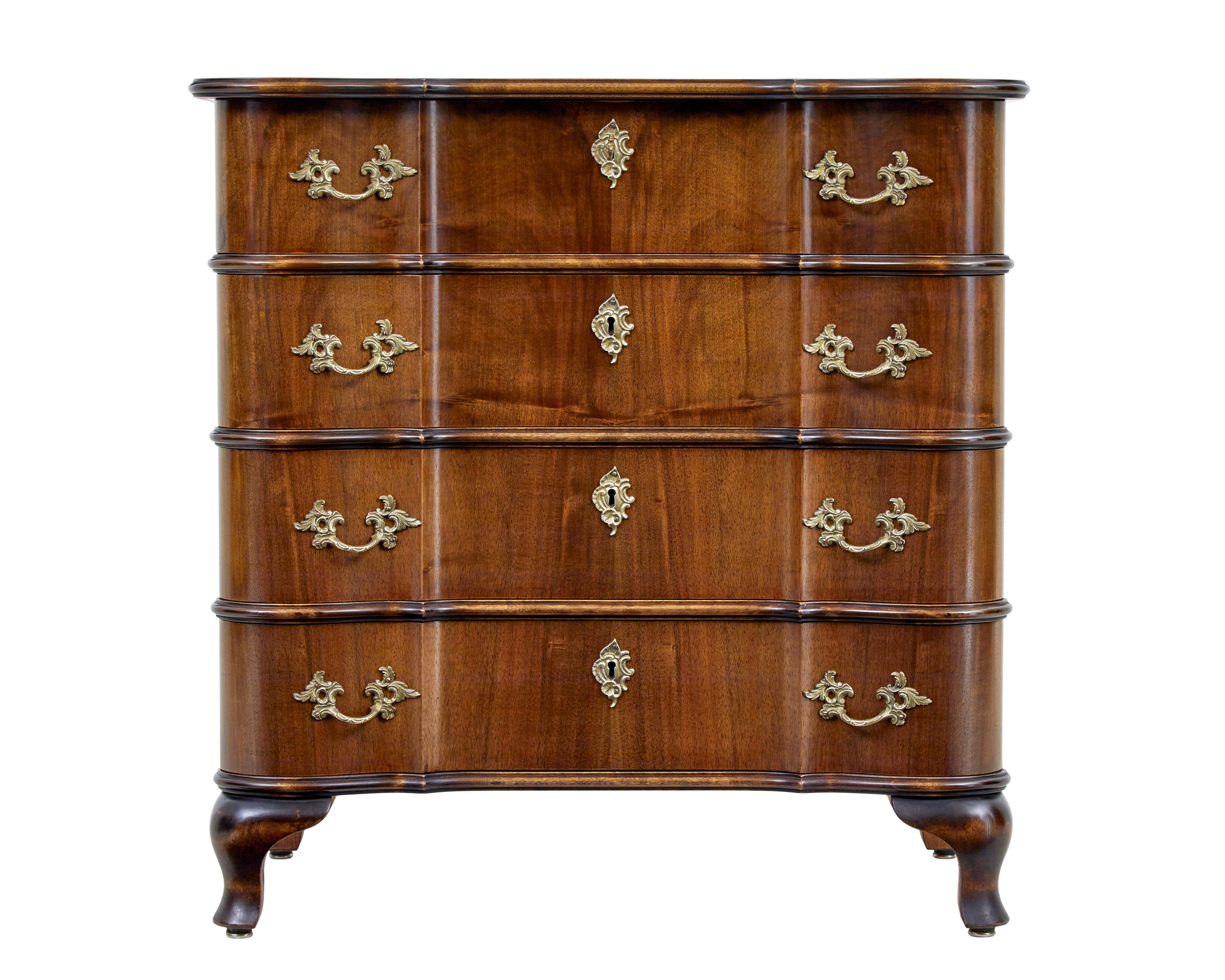 Mid 20th century baroque inspired walnut chest of drawers circa 1950.

Elegant serpentine shaped walnut commode of petit proportions.

4 drawer chest with shaped drawer fronts and top.  Fitted with ornate brass handles and escutheon