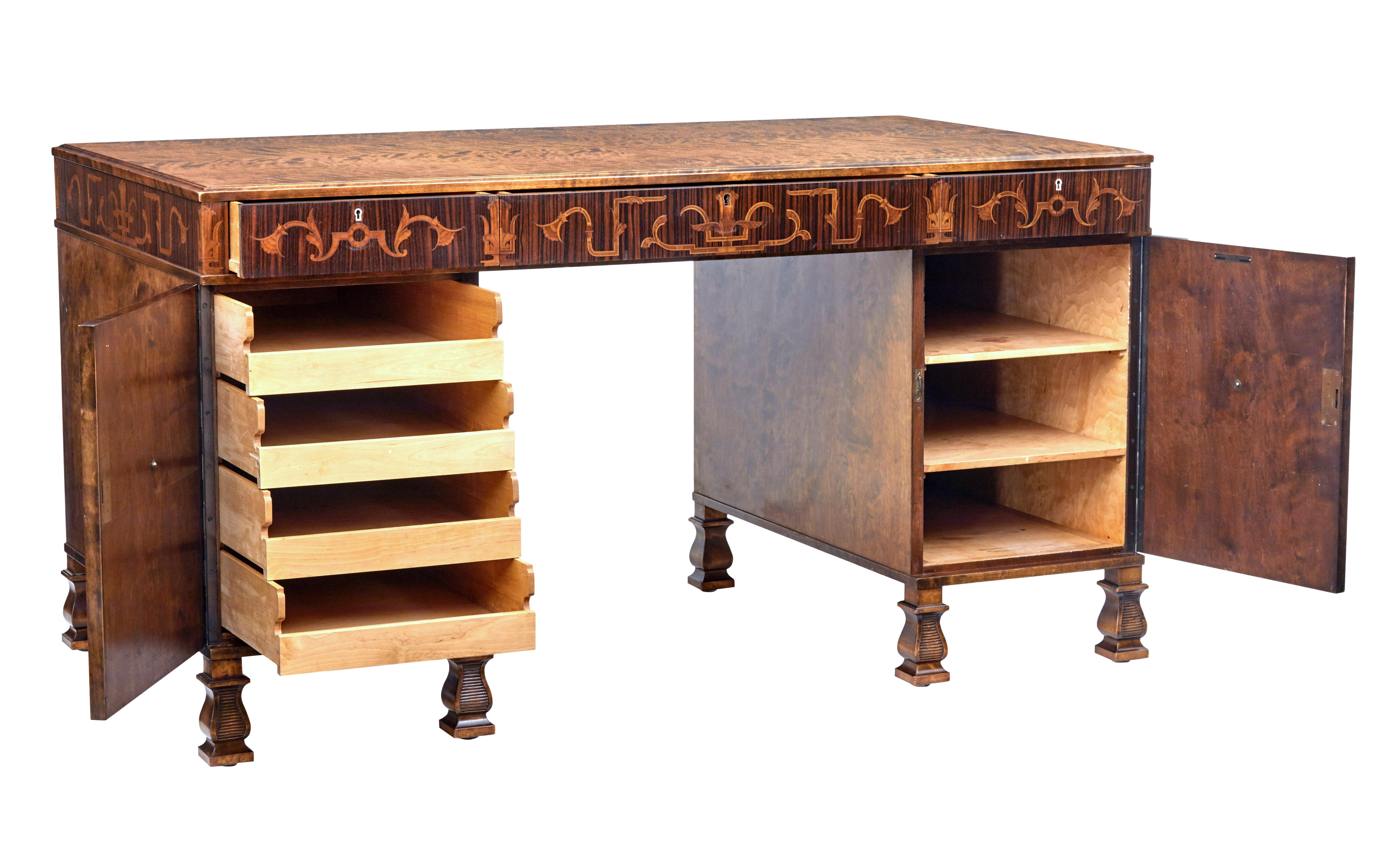 Fine quality 3 piece pedestal desk designed by Carl Malmsten for Bodafors, circa 1940.

Burr birch writing surface below which is an elaborate inlaid frieze of Brazilian rosewood, walnut and satinwood. 3 drawers above the knee.

Left hand