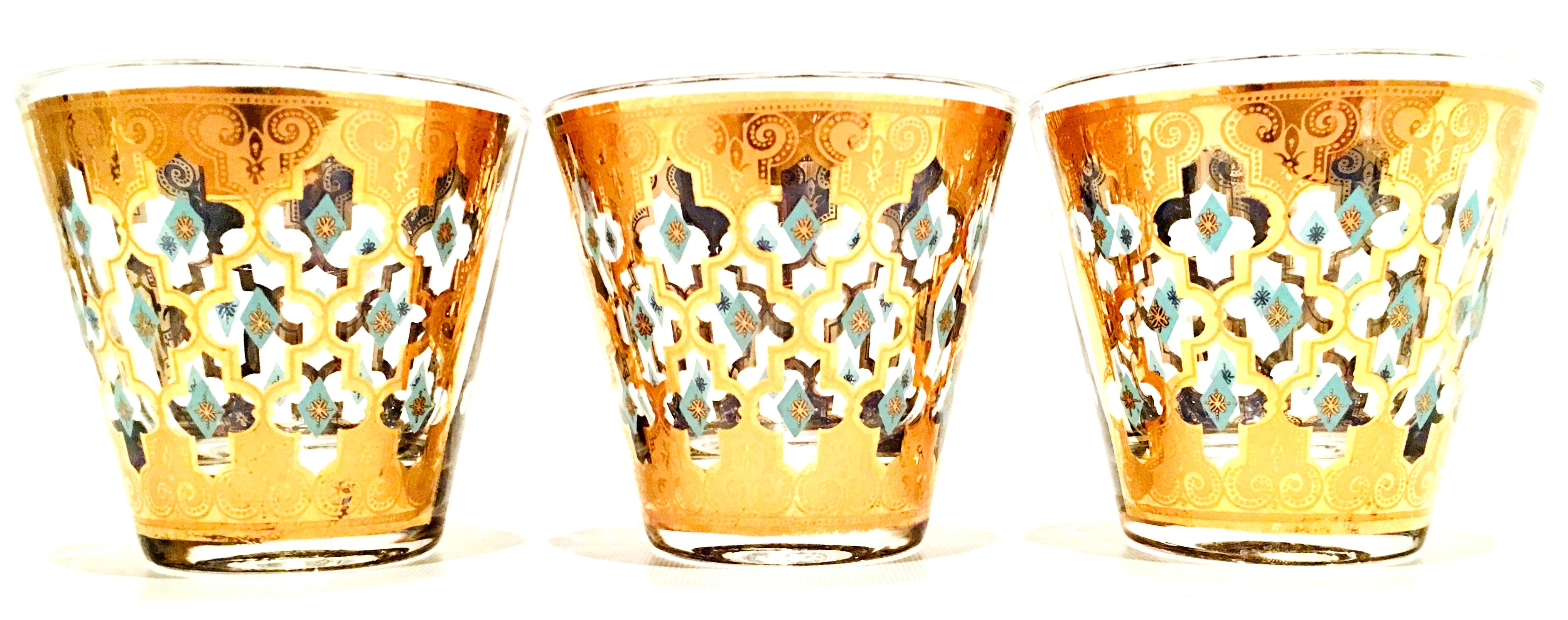 Mid-20th century blown glass drinks set of four pieces by, culver. This 4 piece set includes, three culver double old fashion glasses 22k gold embellished with blue diamond pattern and one genie style vibrant blue decanter bottle.
The culver