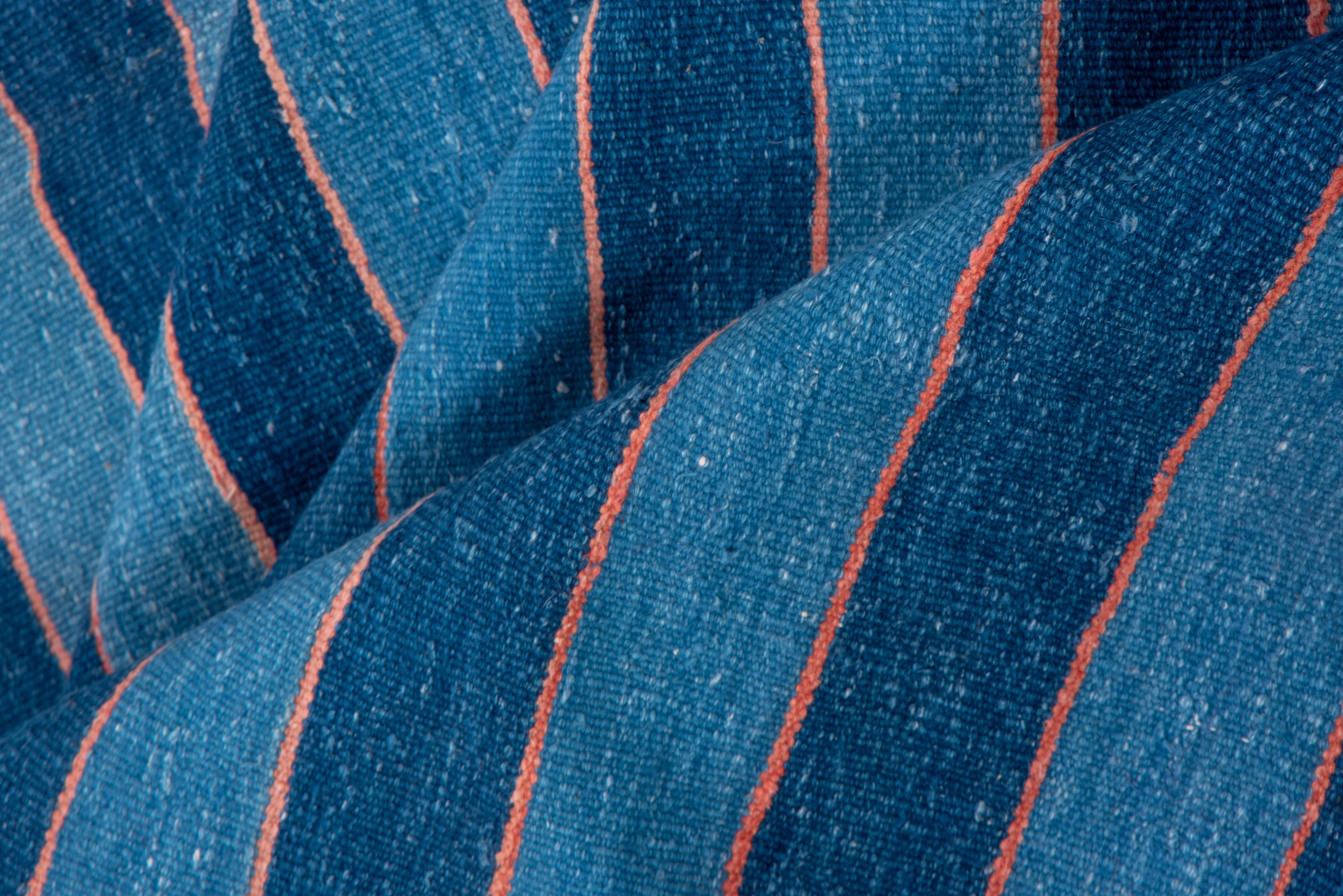 Rarely are dhurries signed by the head of the workshop. Narrow straw lines divide the lighter and darker blue stripes with their delicate internal variations, no two stripes alike. All cotton construction.