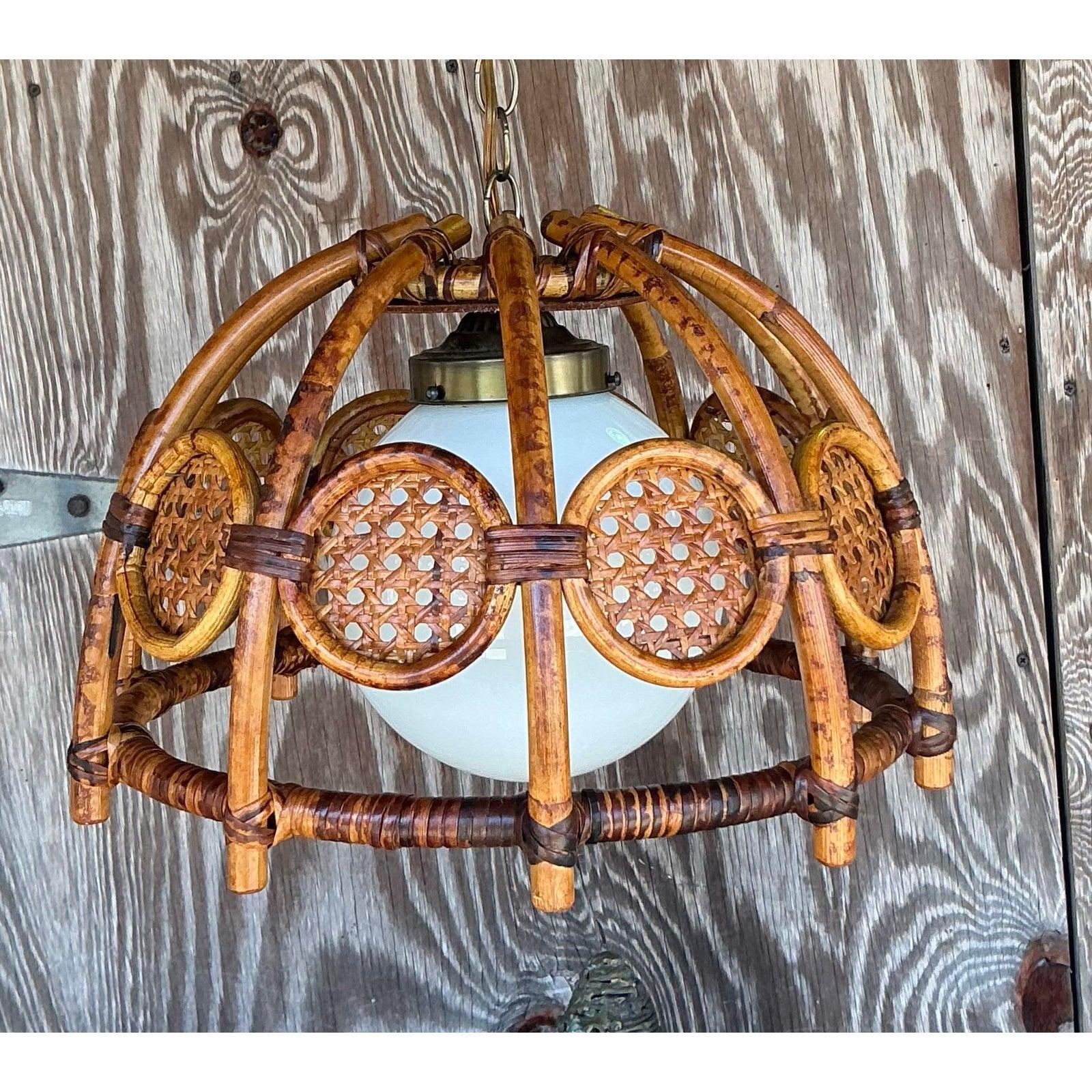 Dai un tocco di naturalezza e fascino bohémien alla tua casa con questo lampadario o lampada a sospensione vintage, splendidamente realizzato in bambù o rattan piegato e pannelli di canna intrecciati. Il telaio è formato da pezzi di bambù o rattan