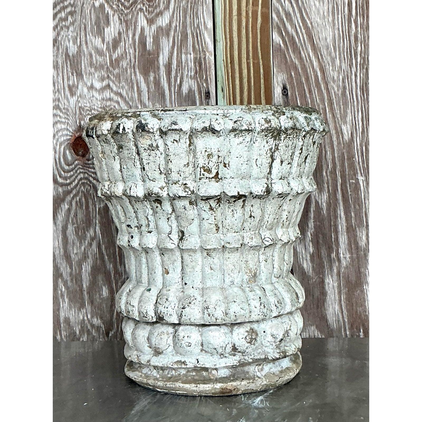 Infuse your space with timeless architectural character with this vintage cast stone planter. Crafted with a substantial, sculptural form, it features repeating ribbed and beaded details that add a touch of classical elegance. Its most captivating