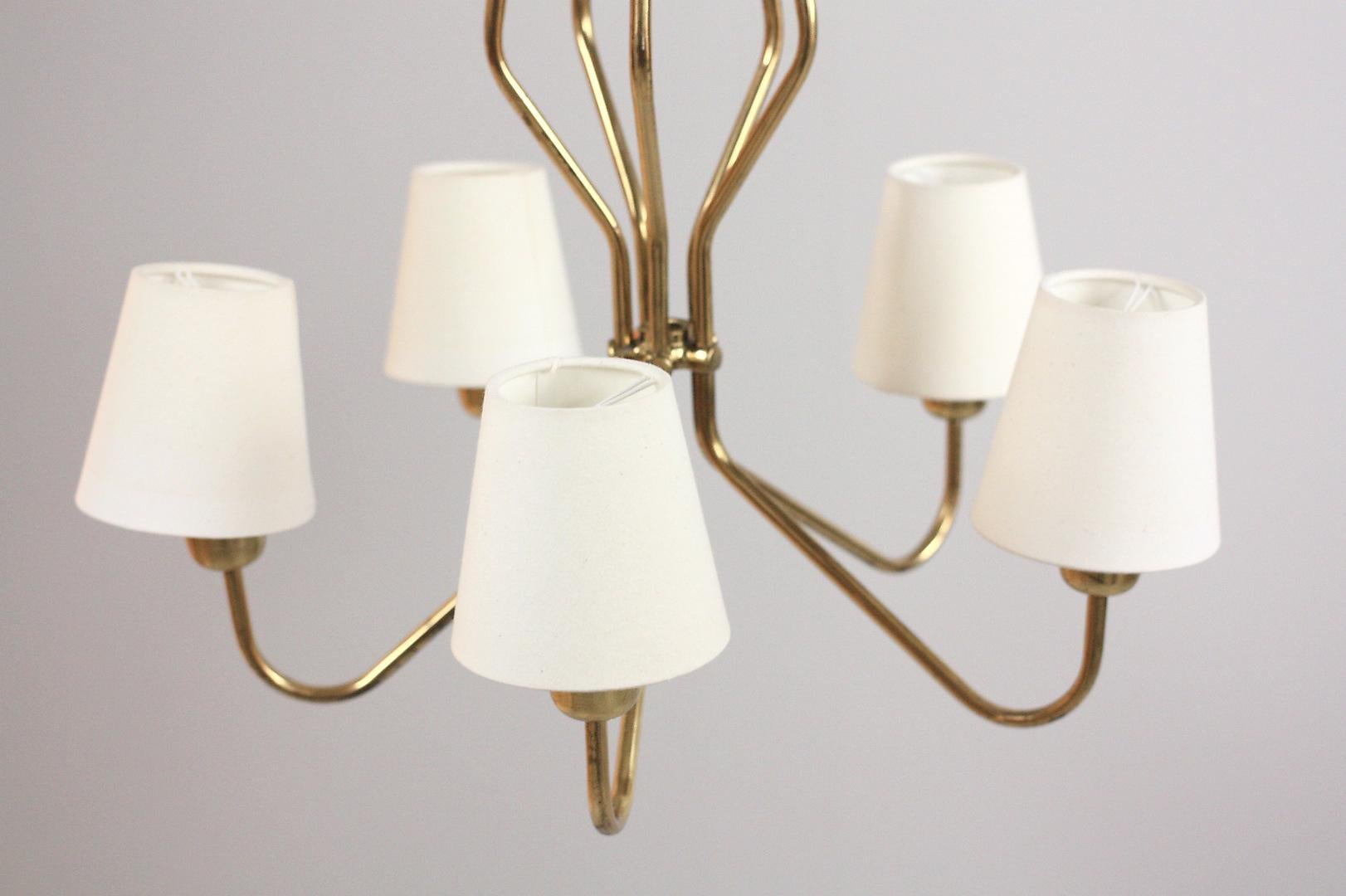 Midcentury brass chandelier with five bulbs. This beautiful midcentury light can have the cords (additional cost) be changed to any color wire or cloth wire. Original shades.
