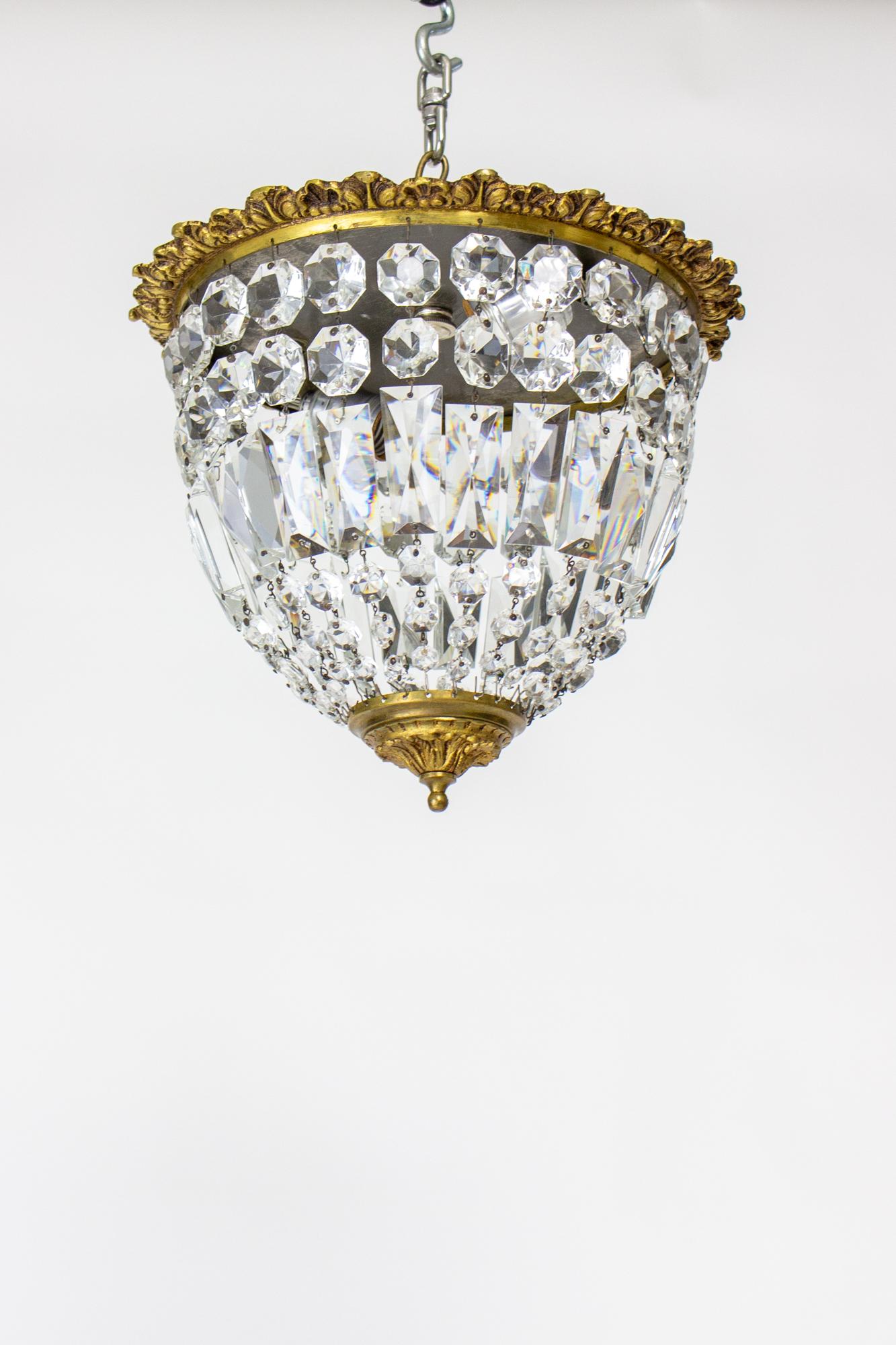 Mid 20th Century brass and crystal basket flush mount fixture. Ornate cast brass frame sits flush to the ceiling with crystal strands draping to a center bottom brass dish. Suitable for low ceilings and a small entry, hallway, or powder room. Two