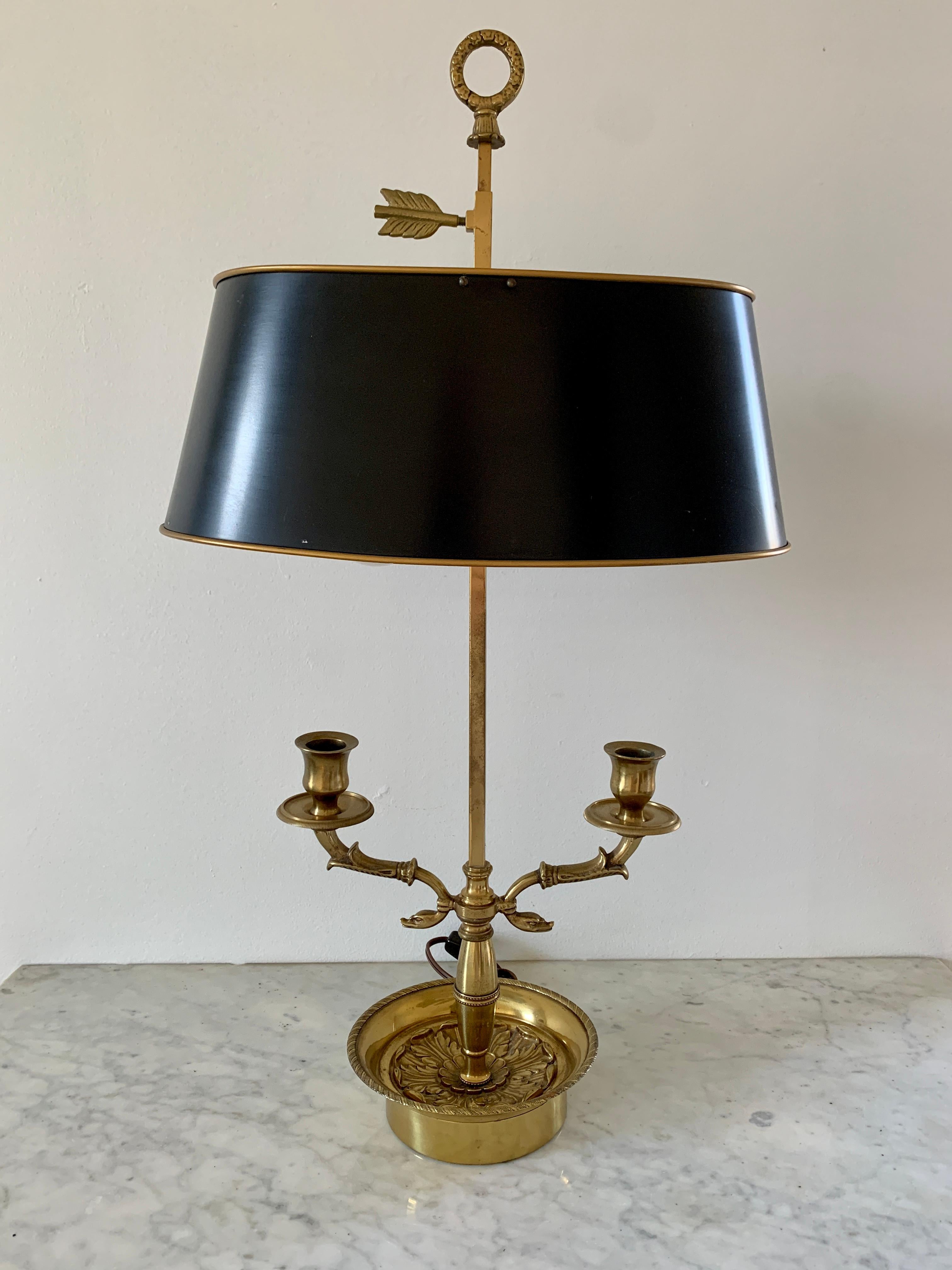 A gorgeous brass double dolphin bouillotte lamp with black tole shade

USA, Mid-20th Century

Measures: 13.75