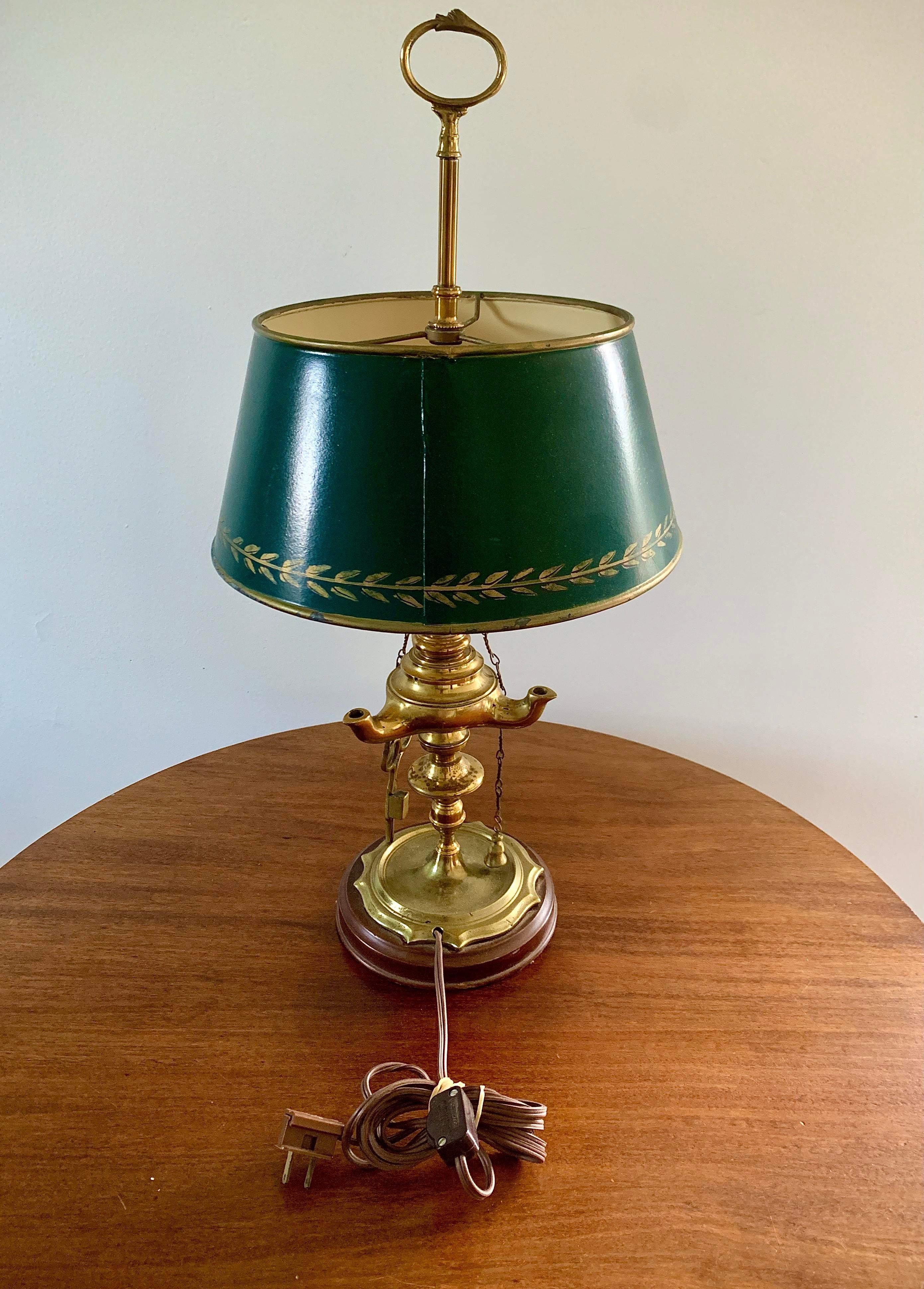 A gorgeous brass bouillotte lamp with a green tole shade, with hanging snuffer & scissors

USA, Mid-20th Century

Measures: 11