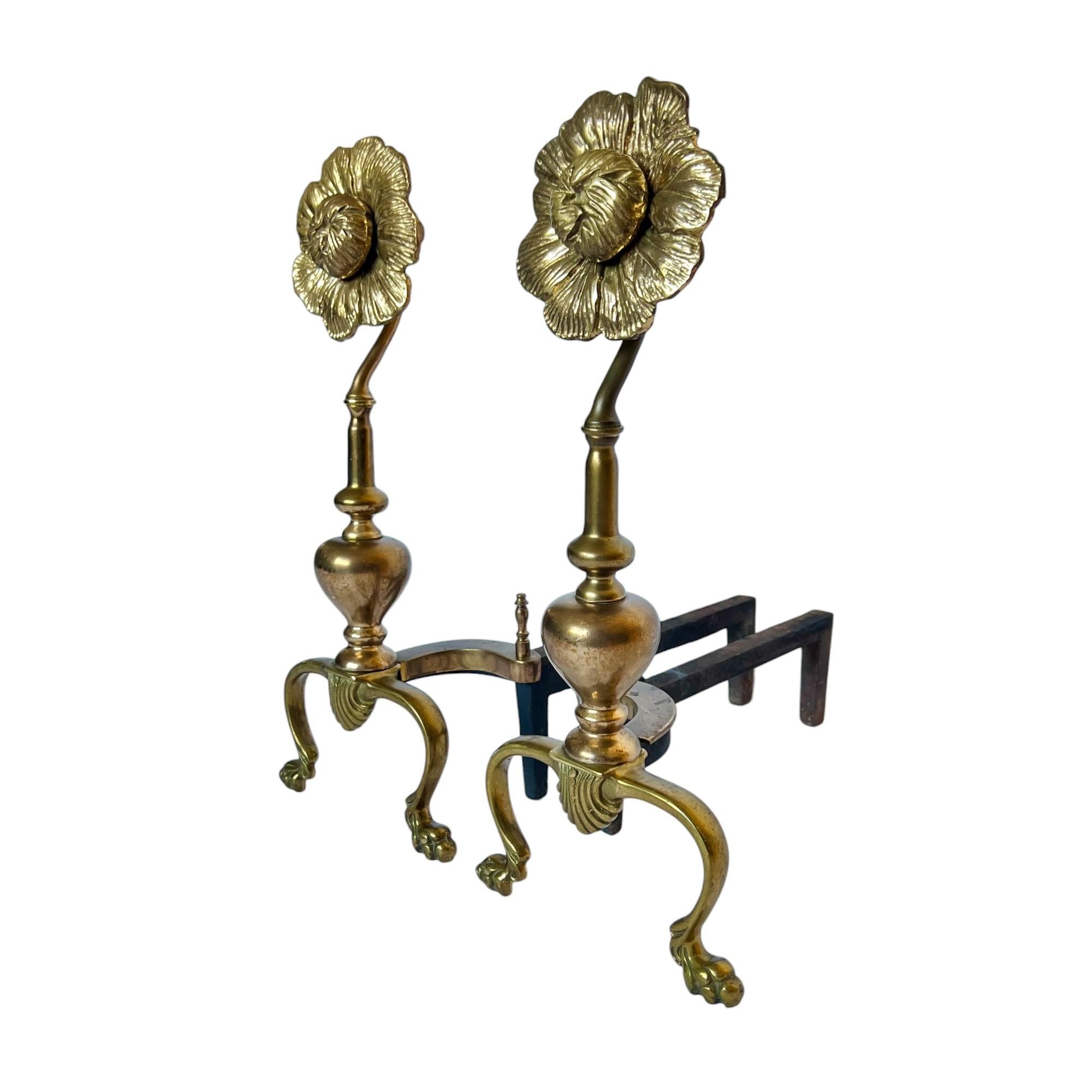 A uniquely beautiful pair of mid 20th century Hollywood regency andirons or chenets featuring a flower shaped top, scalloped detail and paw feet. Polished cast brass and iron.

Dimensions: 8.25