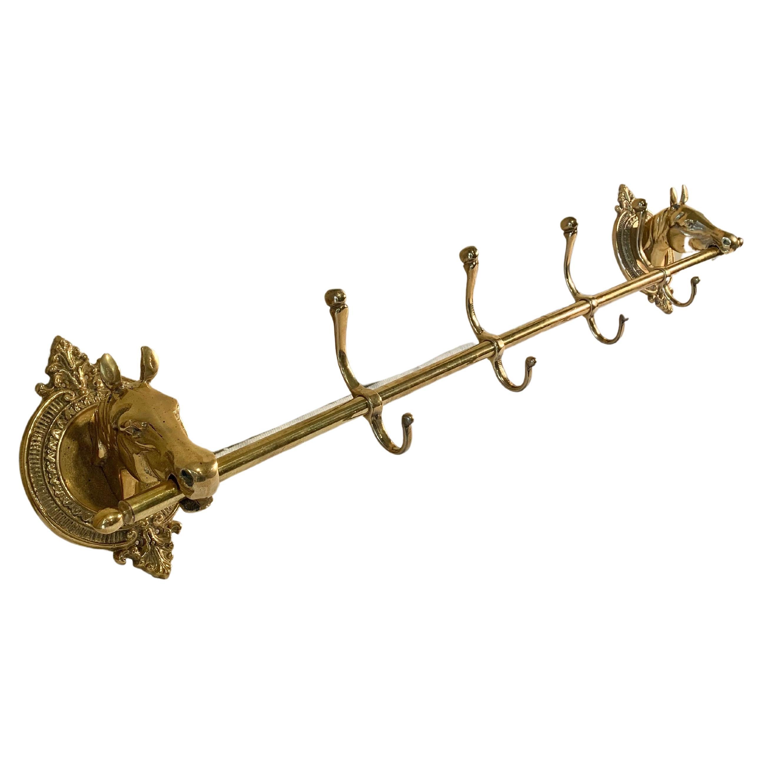 Ce grand porte-manteau ou porte-chapeau à tête de cheval du milieu du XXe siècle a été fabriqué en laiton au milieu des années 1900. La pièce présente deux têtes de cheval montées sur des plaques ovales en laiton aux détails complexes, reliées par