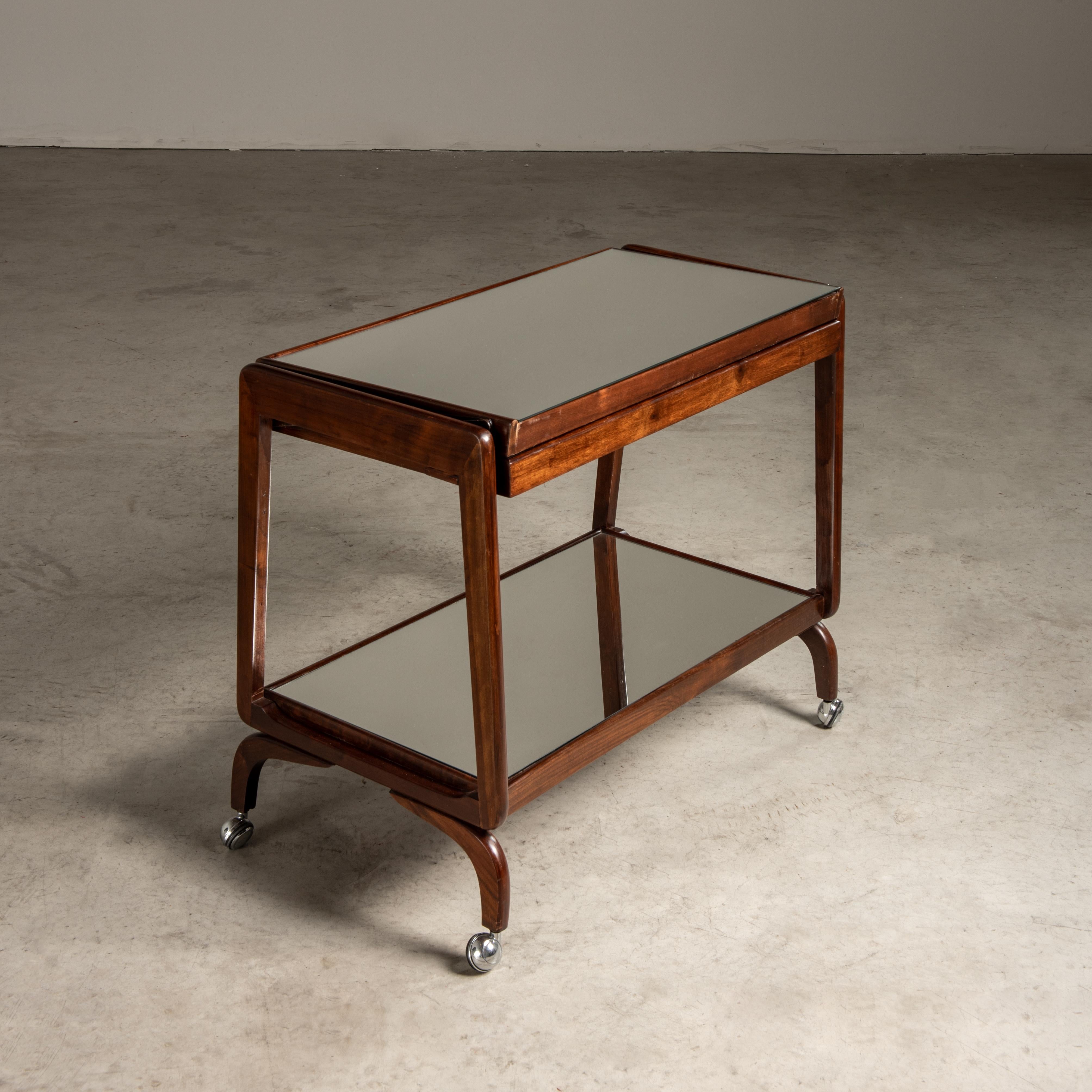 This bar cart is a charming representation of mid-20th-century design, a period that witnessed a remarkable evolution in furniture aesthetics, merging functionalism with the emerging tastes of modernism. The mid-century period, particularly the